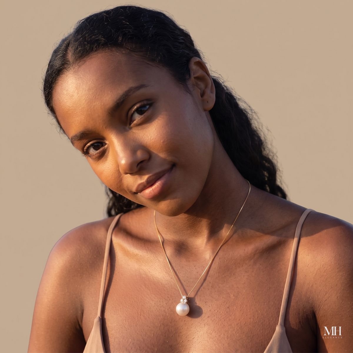 Woman smiling while wearing a dainty 14K gold freshwater pearl pendant necklace