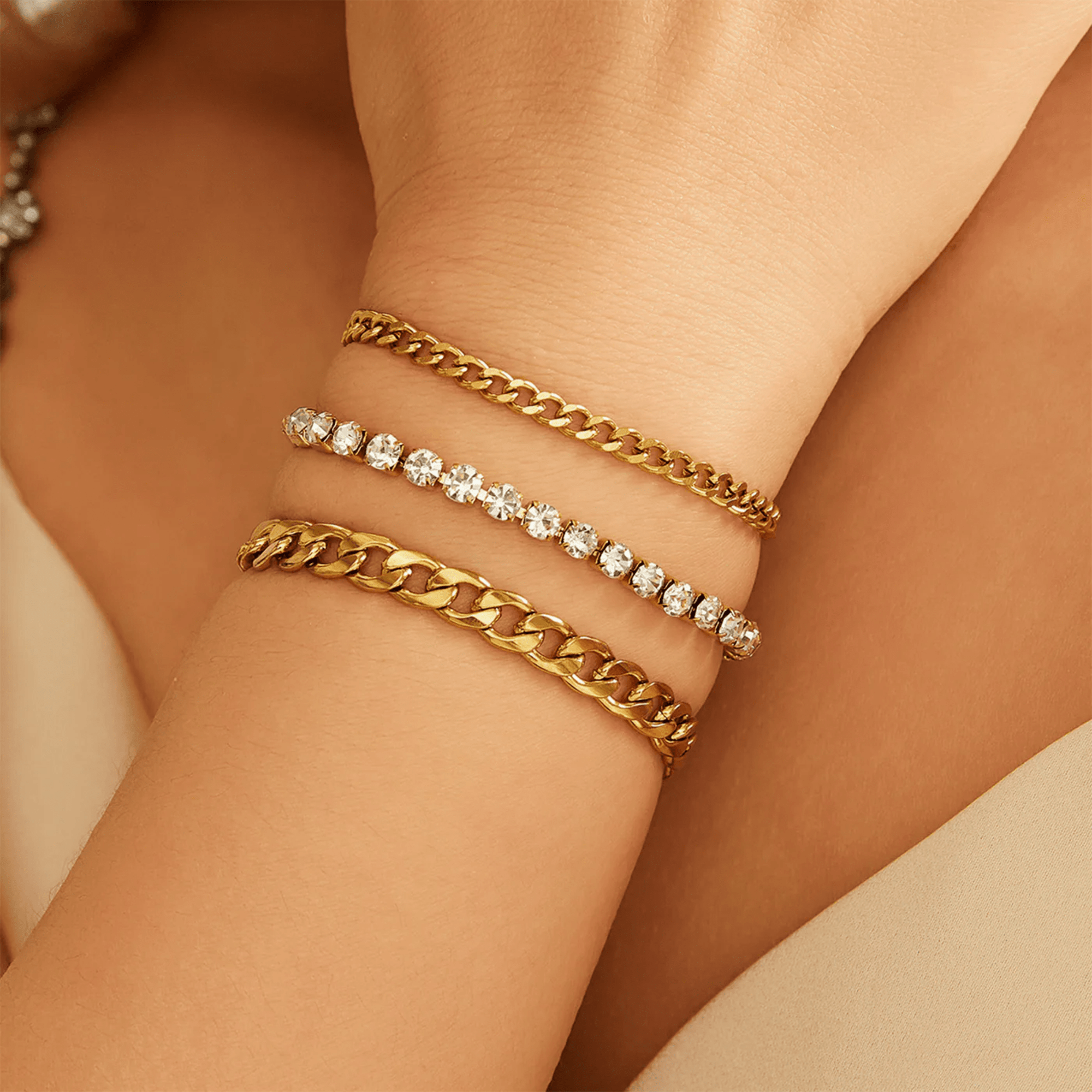 Woman wearing an 18K gold plated Cuban link rhinestone bracelet, everyday glam wrist stack styling