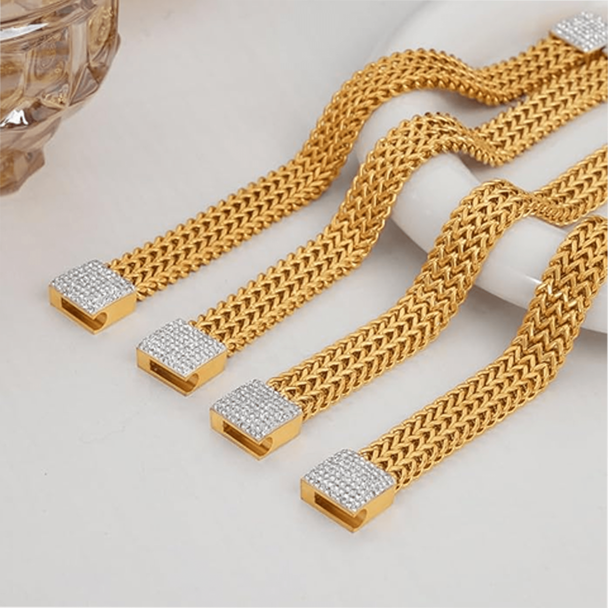 Angled view of the gold-plated mesh bracelet showing its wide, smooth surface