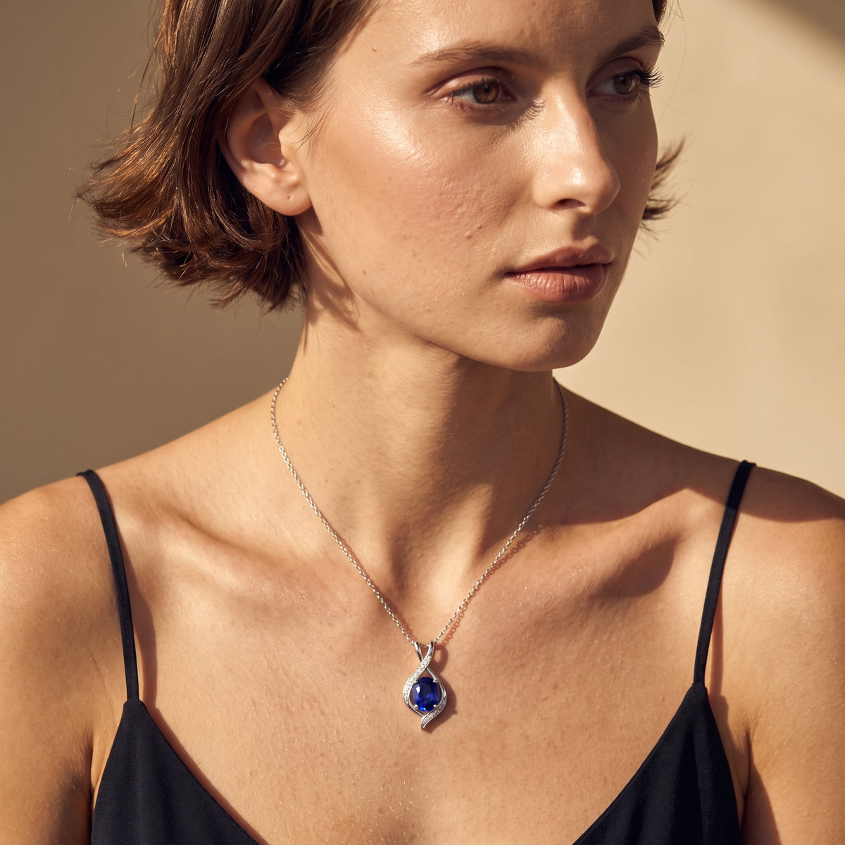 Sapphire birthstone necklace worn on the neck, angled styling shot