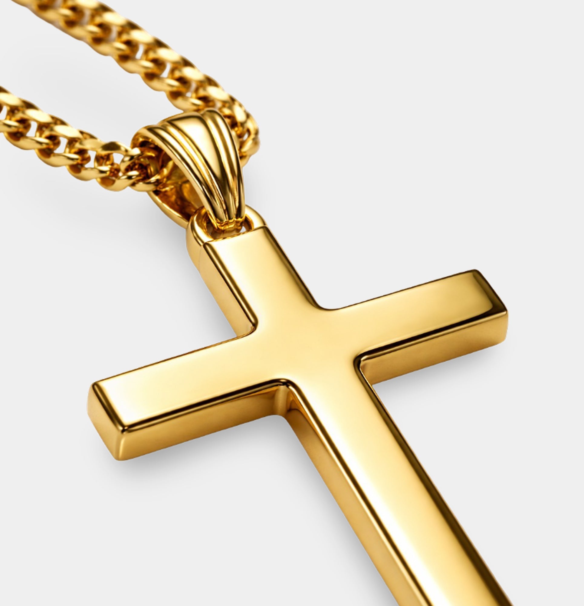 MH Elegance 24K gold cross necklace with diamond-cut Cuban chain shown coiled with the cross pendant