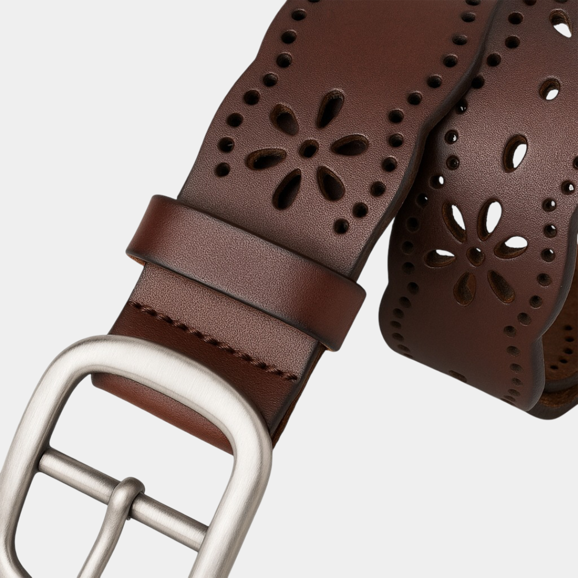Artistic women's leather belt with hollow flower design draped elegantly, demonstrating versatile styling for dress and casual wear