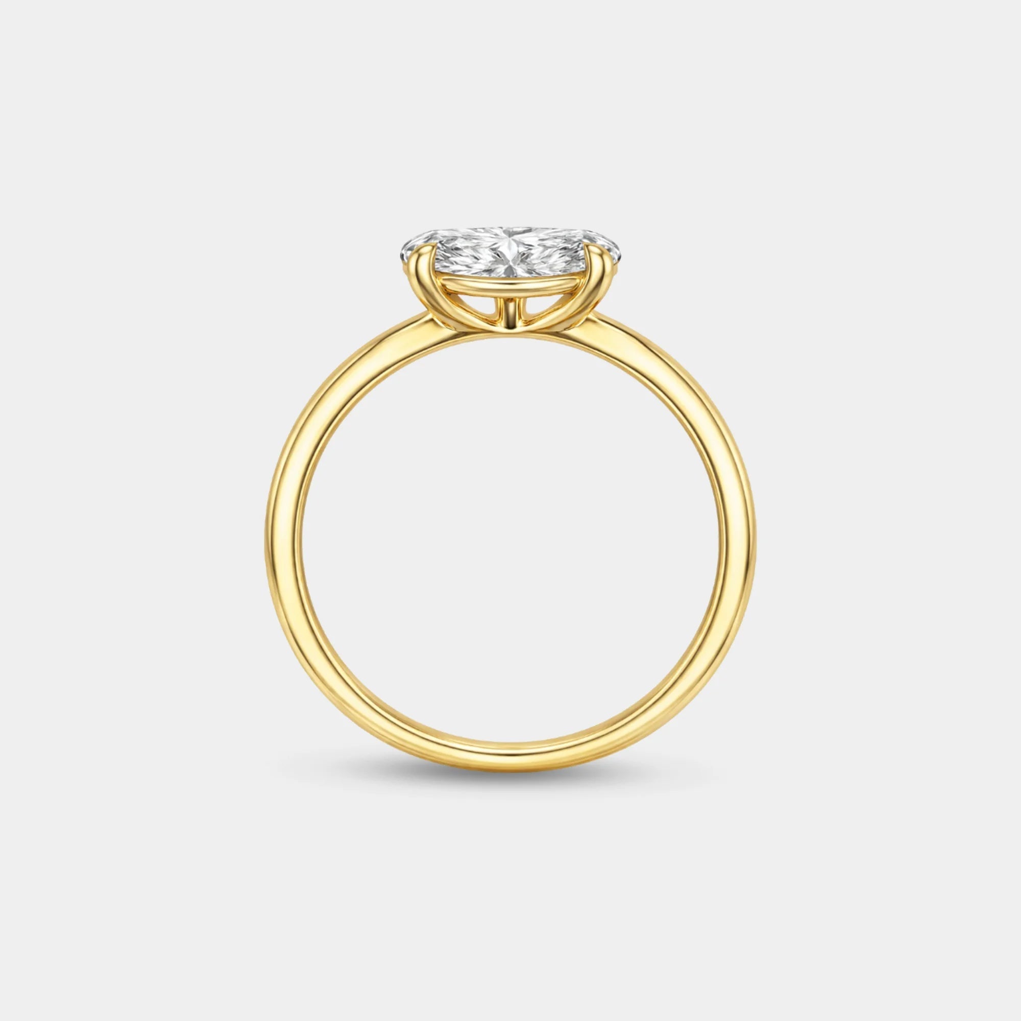 Side angle view of the gold oval solitaire ring showing the raised four-prong setting and slim band