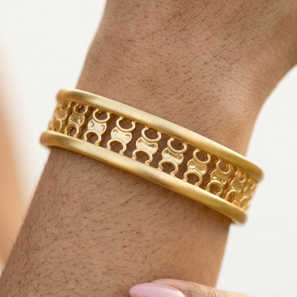 Close view of the cut-out openwork pattern and polished rails on the gold cuff