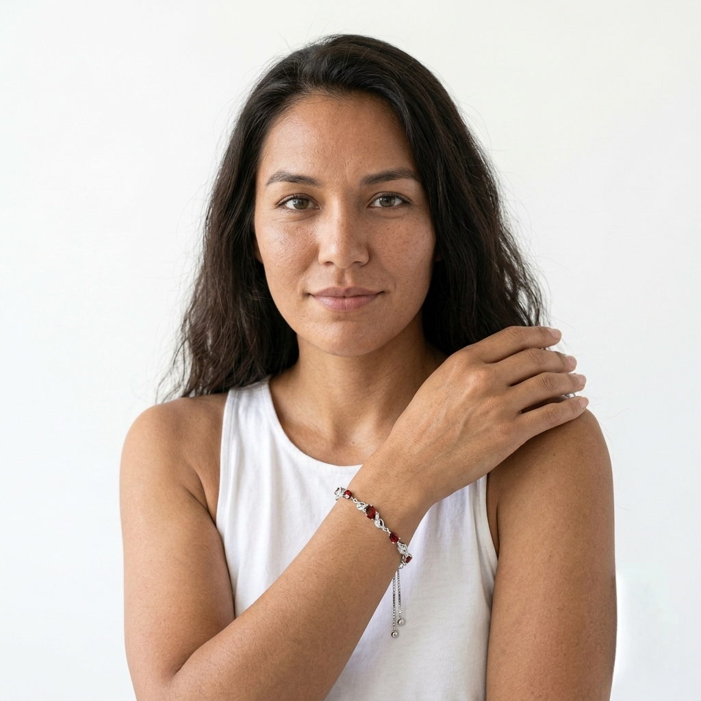 Woman touching her hair while wearing a garnet teardrop tennis bracelet