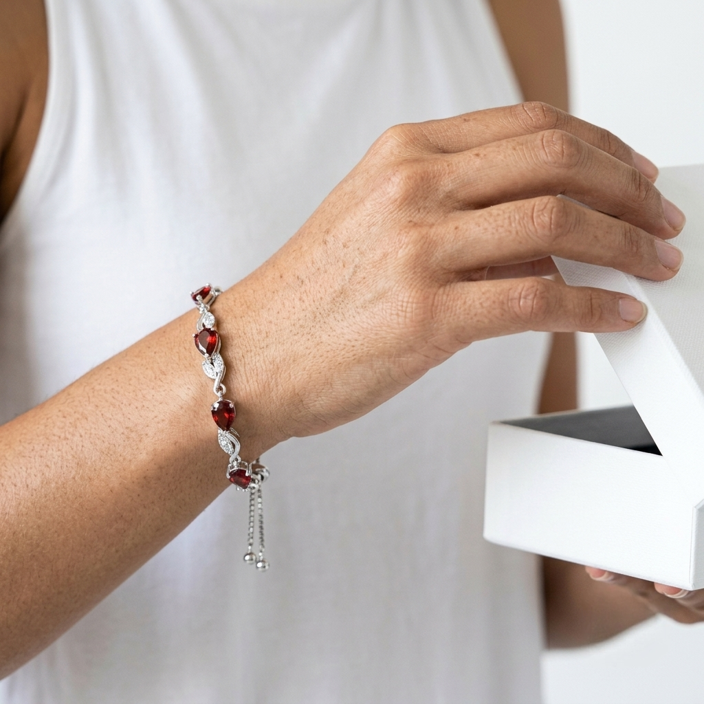 Woman wearing garnet tennis bracelet while opening a gift box