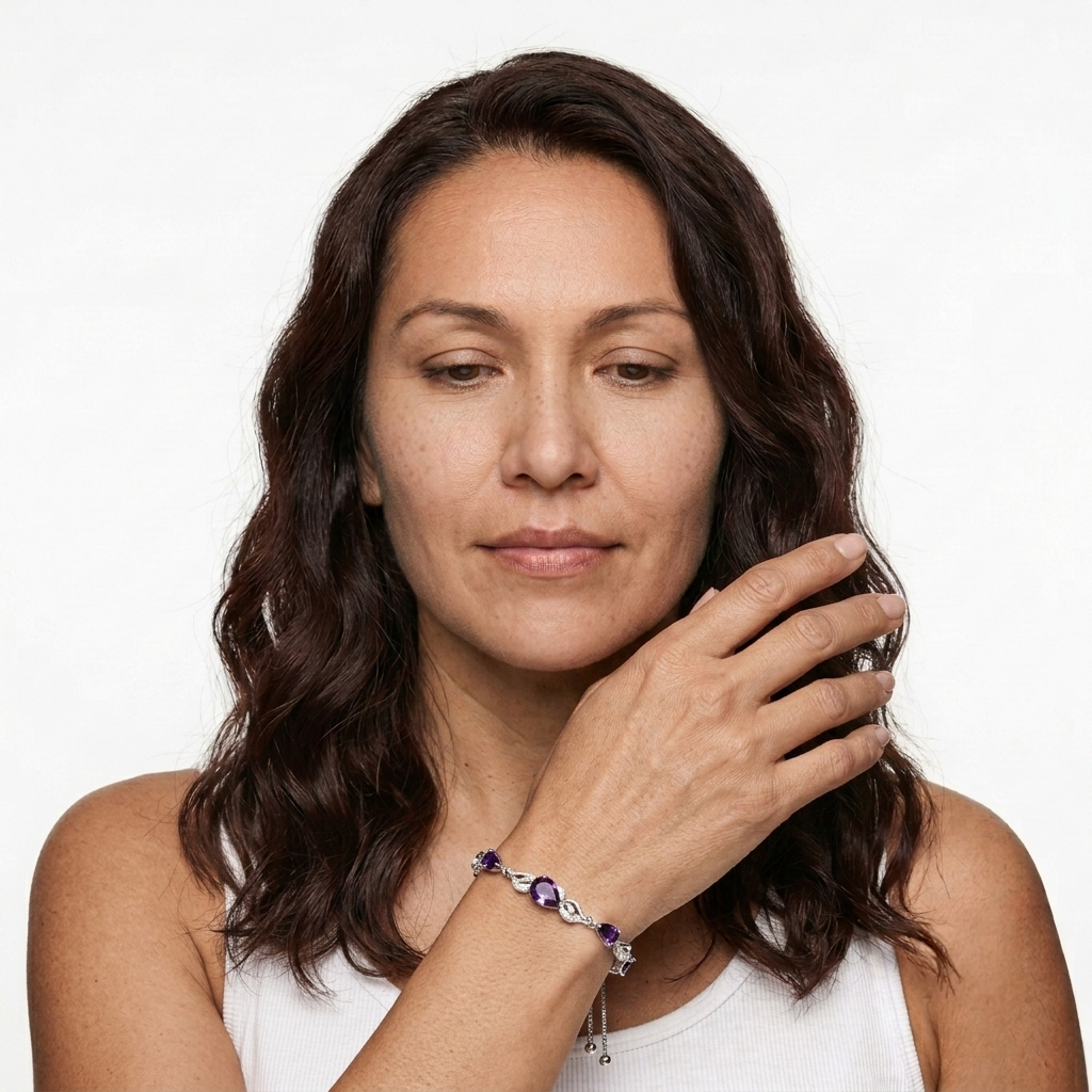 Woman touching her hair while wearing an amethyst teardrop tennis bracelet