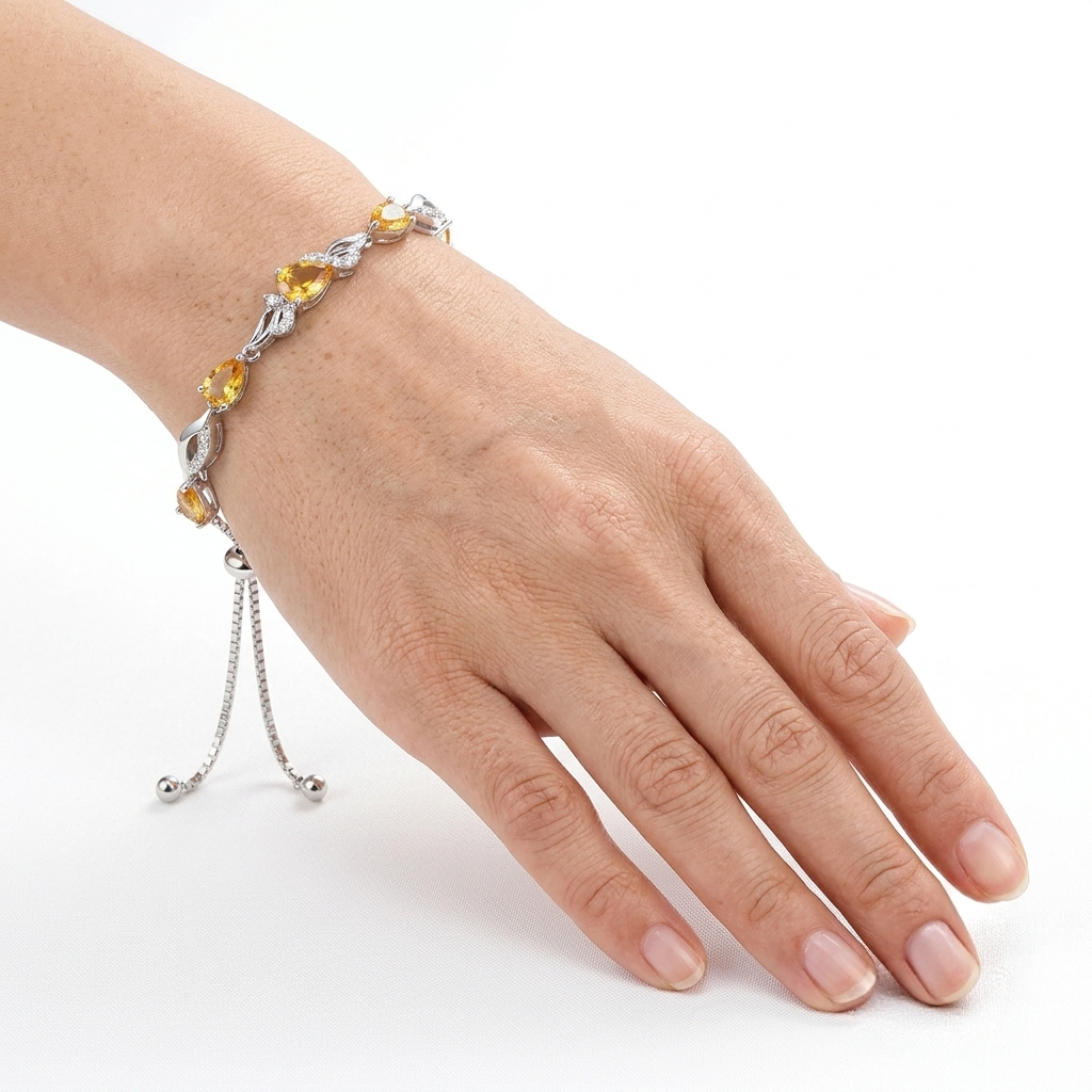 Close-up of the citrine tennis bracelet worn on a wrist, showing the golden yellow teardrop stones.
