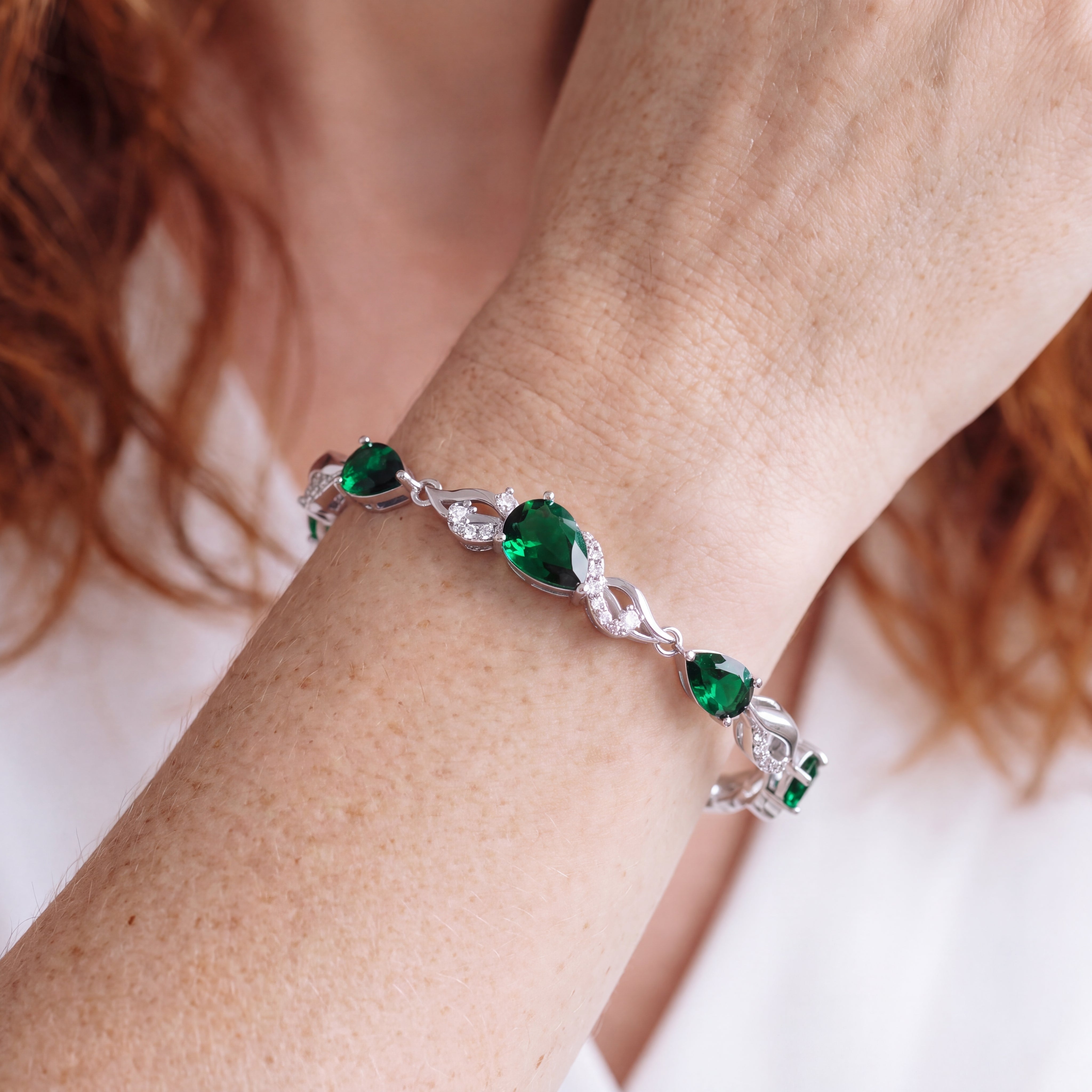 Emerald tennis bracelet worn on the wrist, styling shot