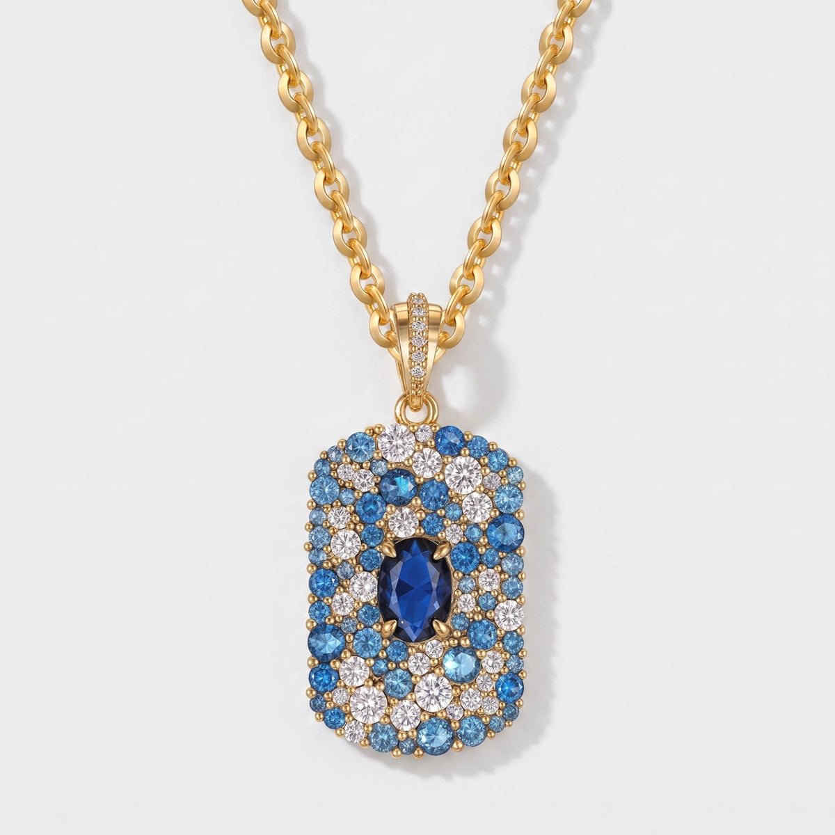 Blue and white CZ pave tag pendant necklace in 14K gold plating with an oval sapphire blue center stone