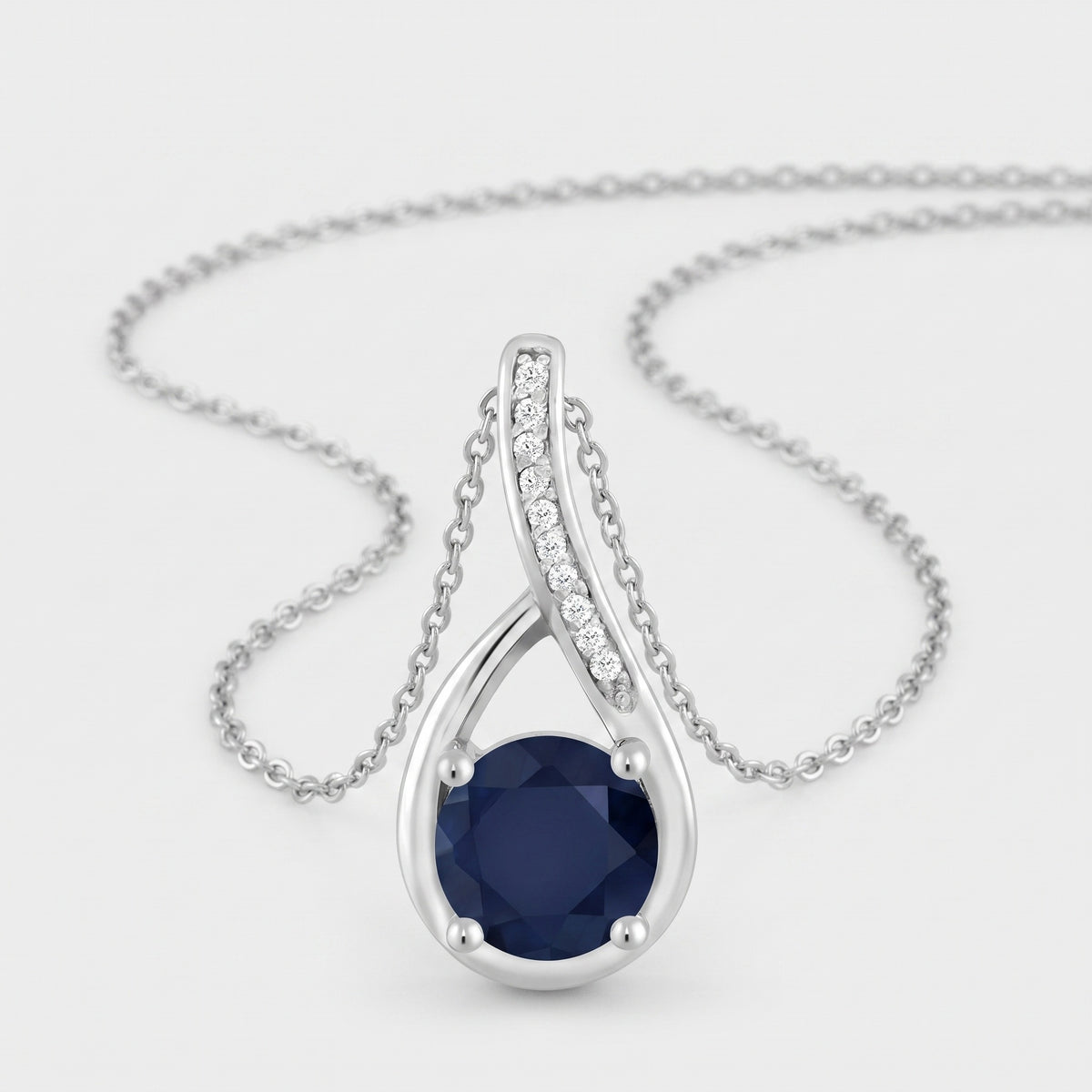 Sterling silver infinity loop pendant with a 6mm round blue sapphire and white diamond accents