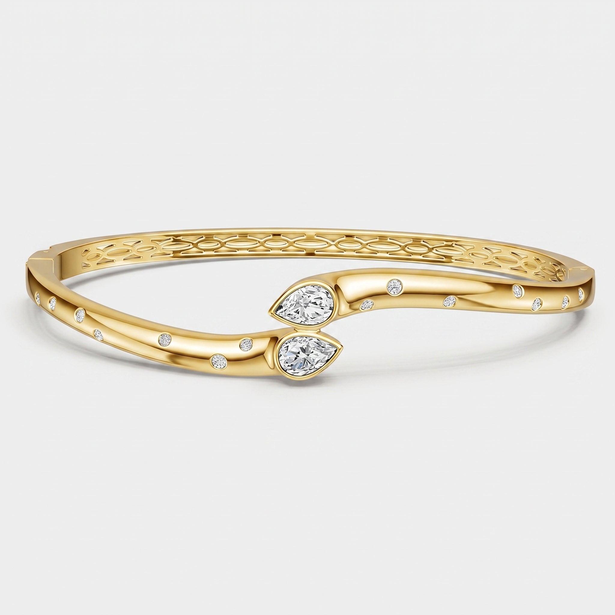 A gold bangle bracelet with a textured honeycomb pattern on the inner band, two leaf-shaped clear gemstones, and small round accent stones, shown on a light gray background.