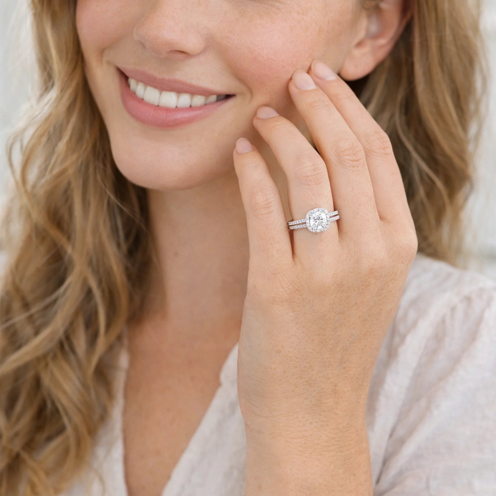 Close-up of moissanite halo engagement ring with natural diamond accent stones in 14K gold setting