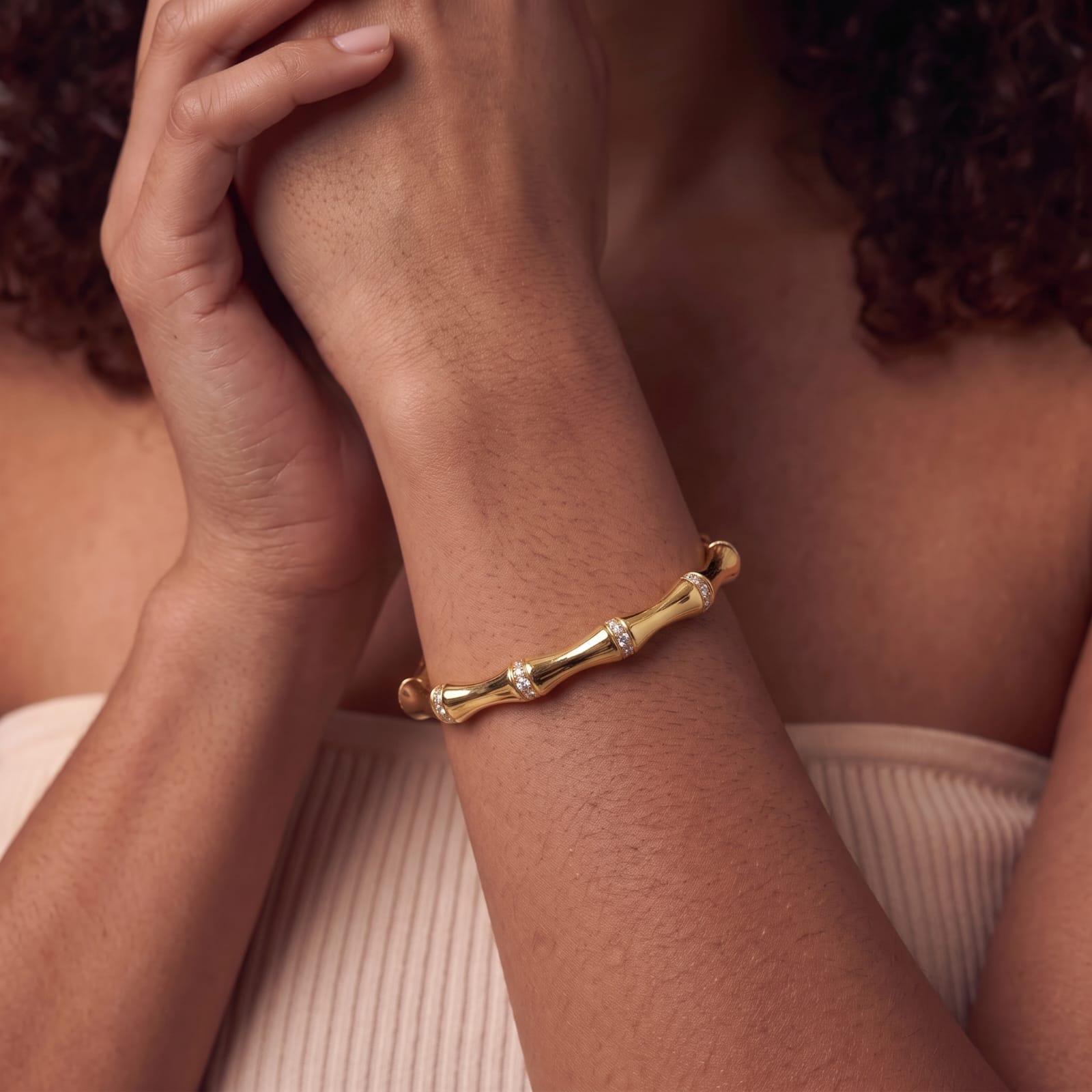 Woman wearing the MH Elegance 14K gold plated bamboo cuff bracelet with pave cubic zirconia at each joint