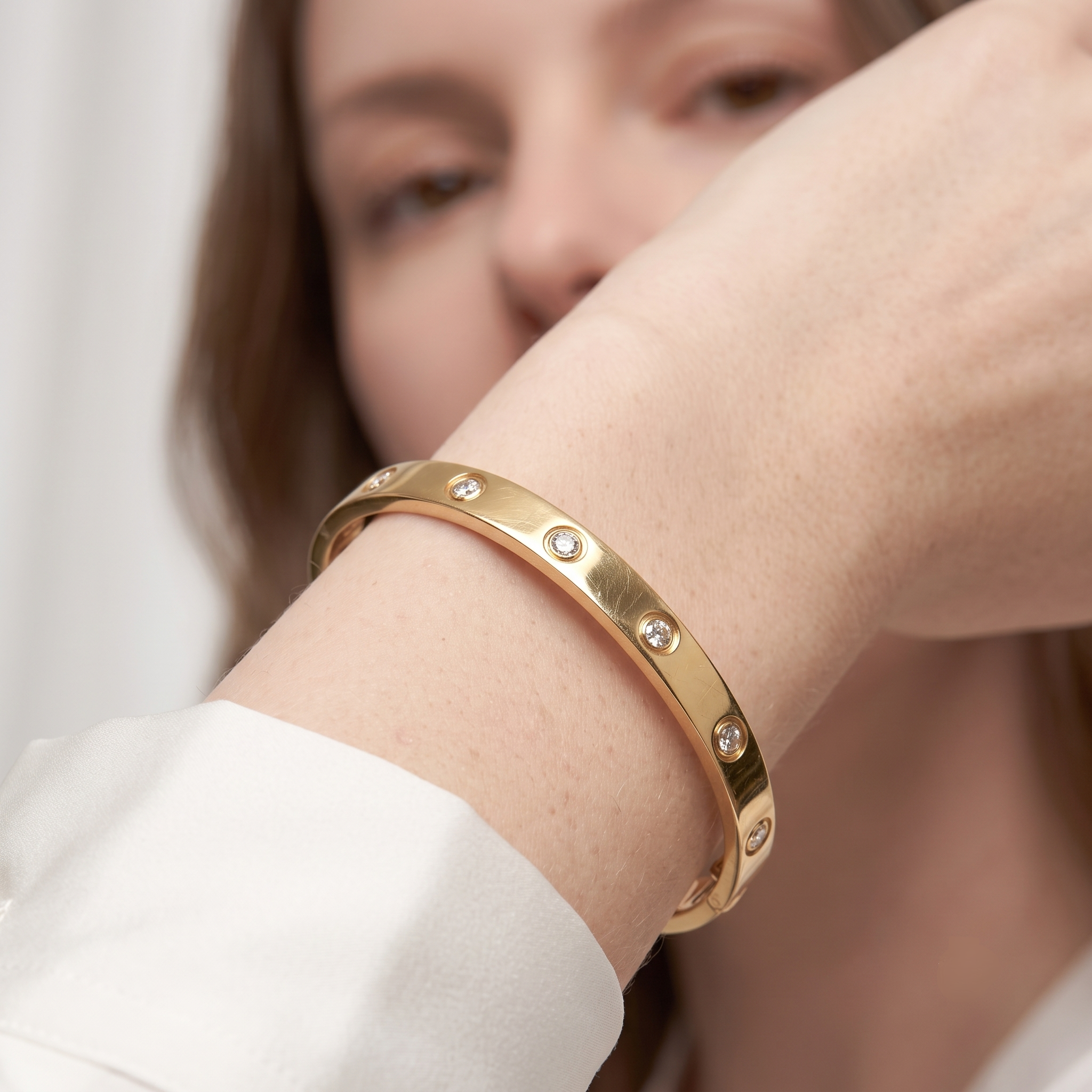 Close-up of round bezel-set cubic zirconia stones on the gold stackable bangle bracelet