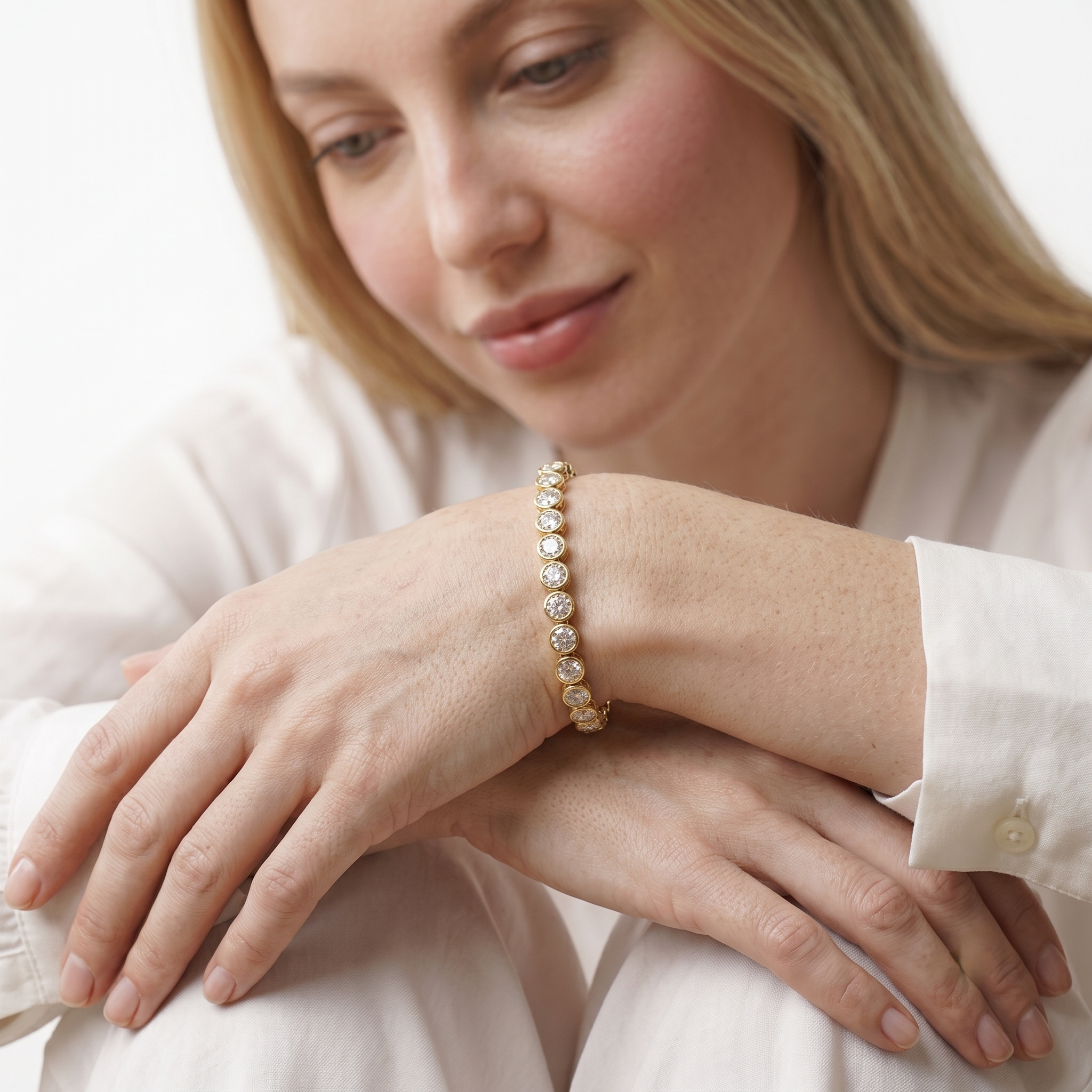 Woman wearing the 14K gold filled bangle bracelet with bezel-set cubic zirconia stones on her wrist