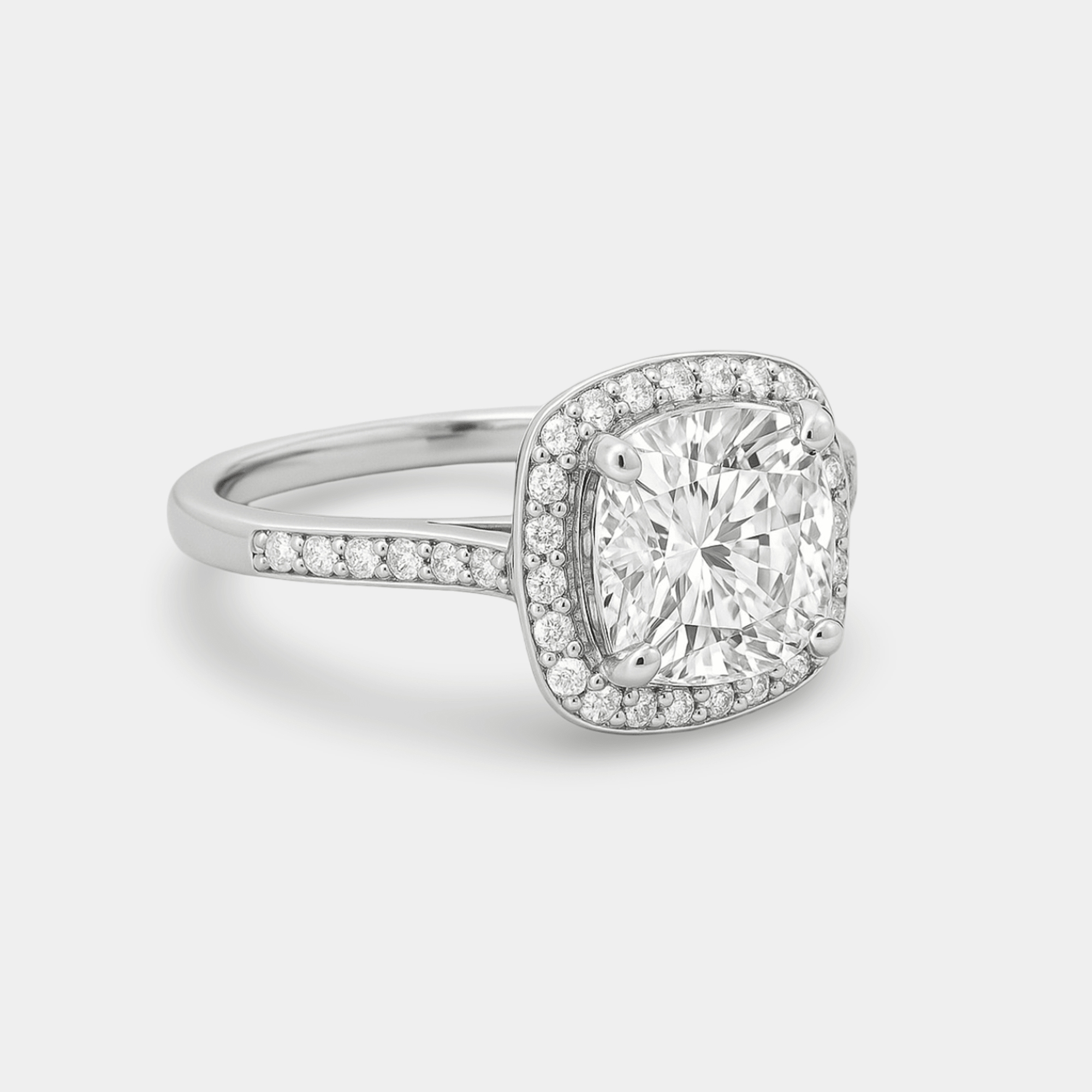 Moissanite cushion halo engagement ring shown worn on a hand