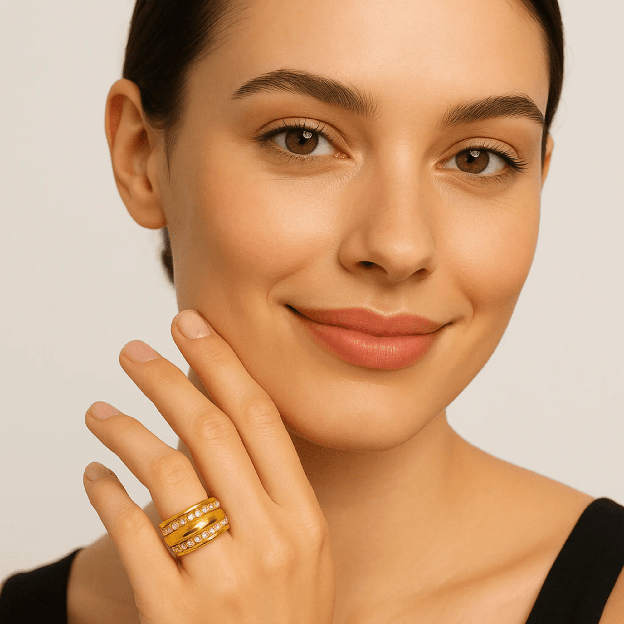 Woman wearing the gilded double row zircon statement ring while touching her cheek