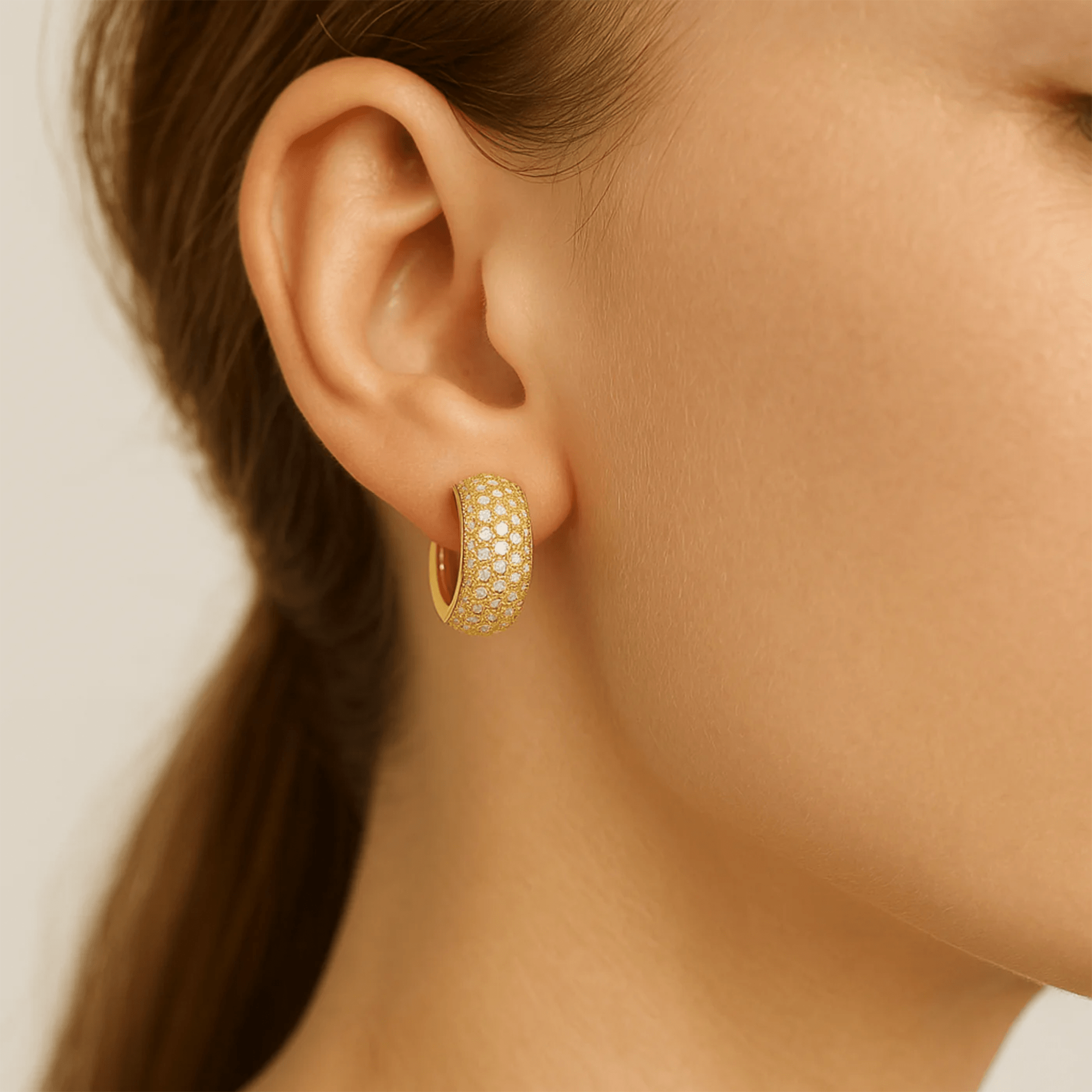 Model wearing GlamBrick pavé crystal gold huggie hoop earring in a close-fit lifestyle photo