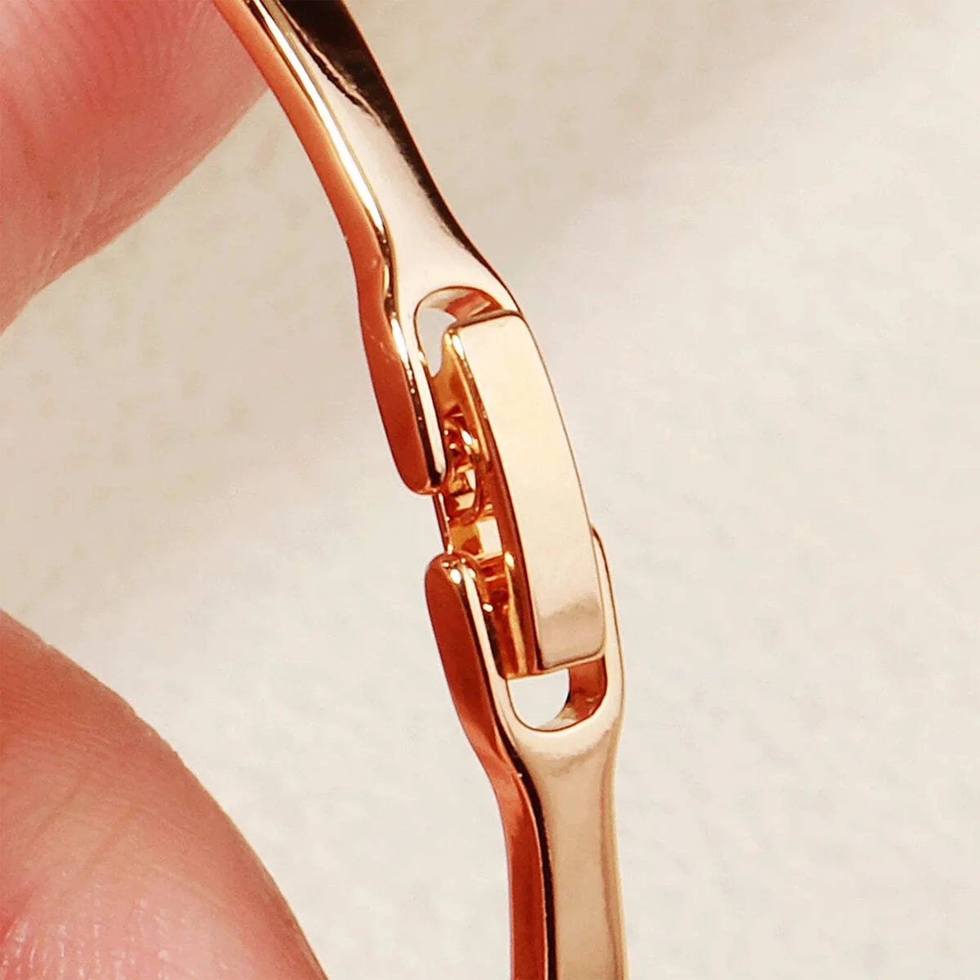 Gold H initial bangle with a hidden safety clasp, detail view