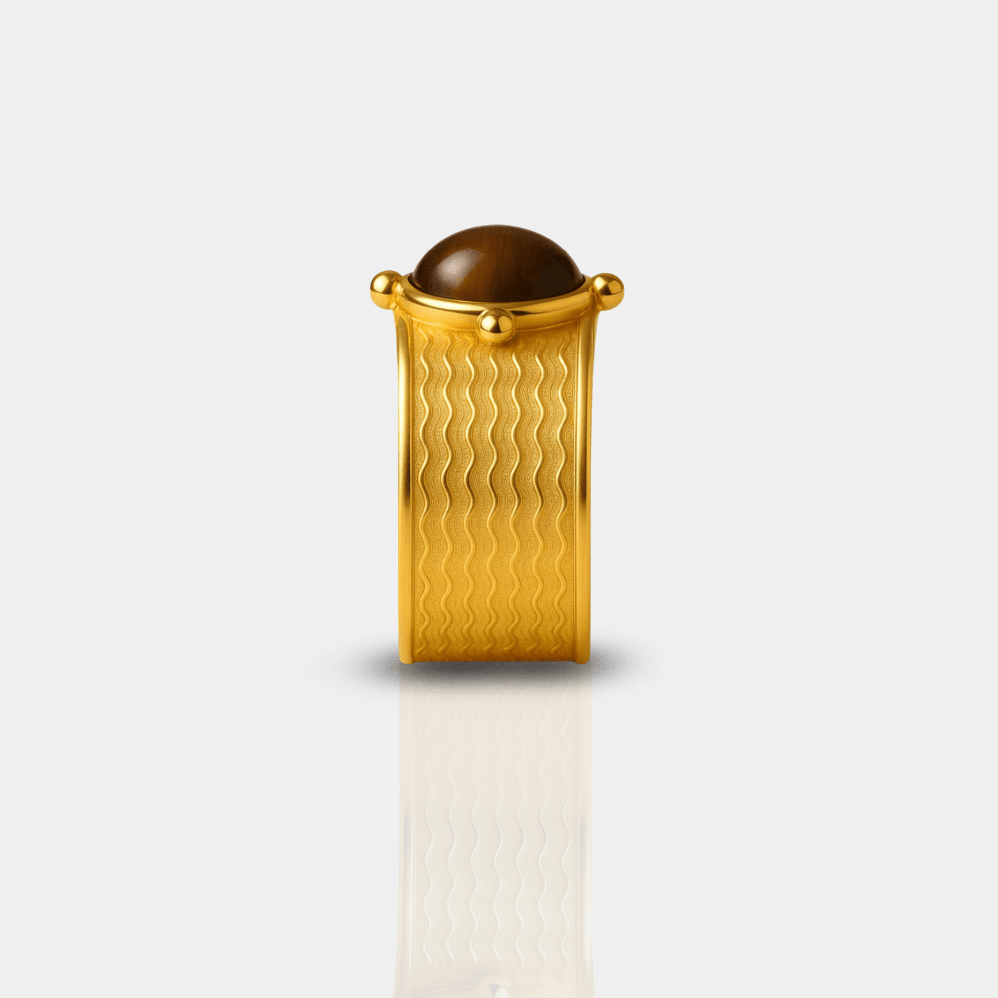 Close-up side view of the tiger's eye stone and ribbed wave texture on the gold cuff ring