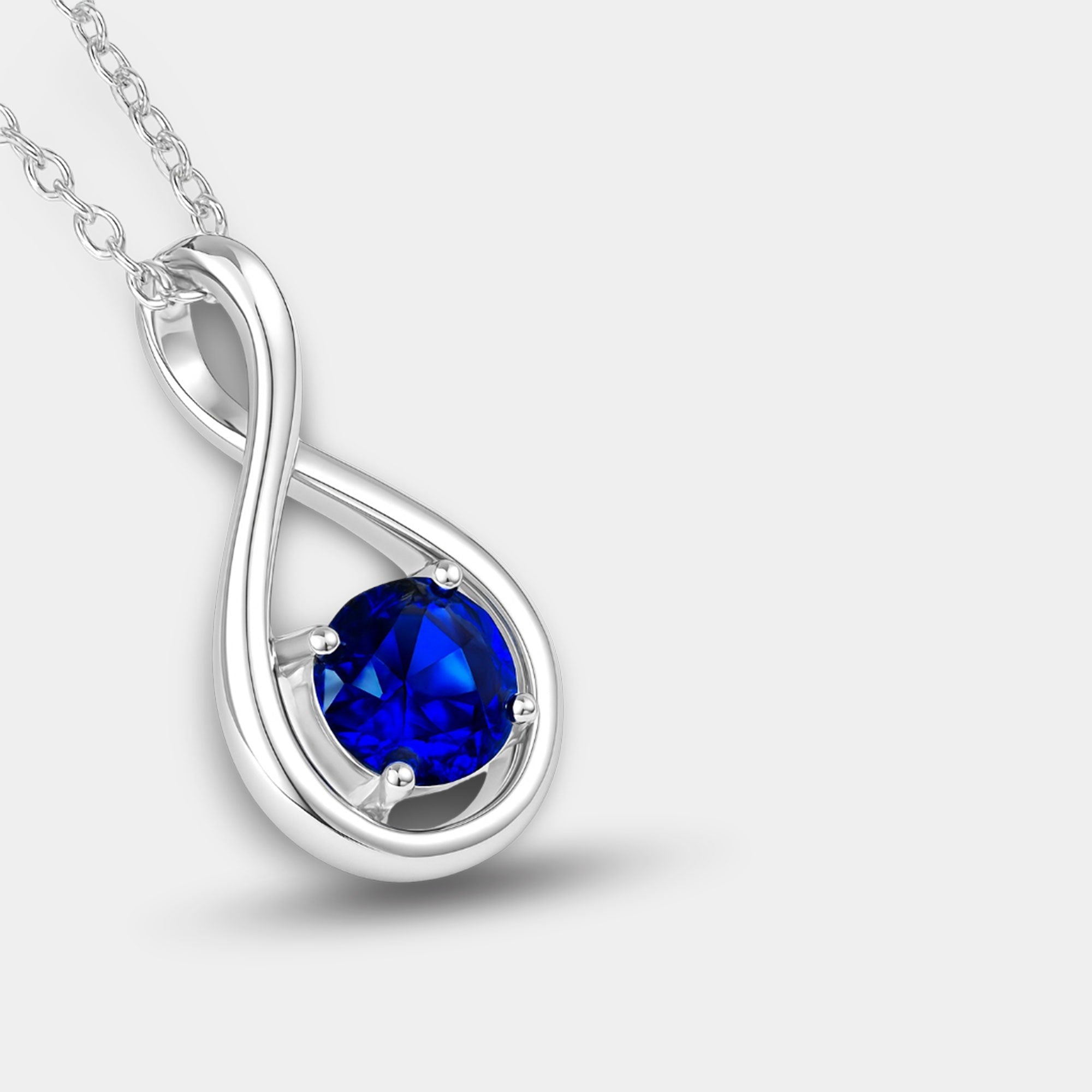 Infinity sapphire necklace shown with its sterling silver cable chain and lobster clasp.