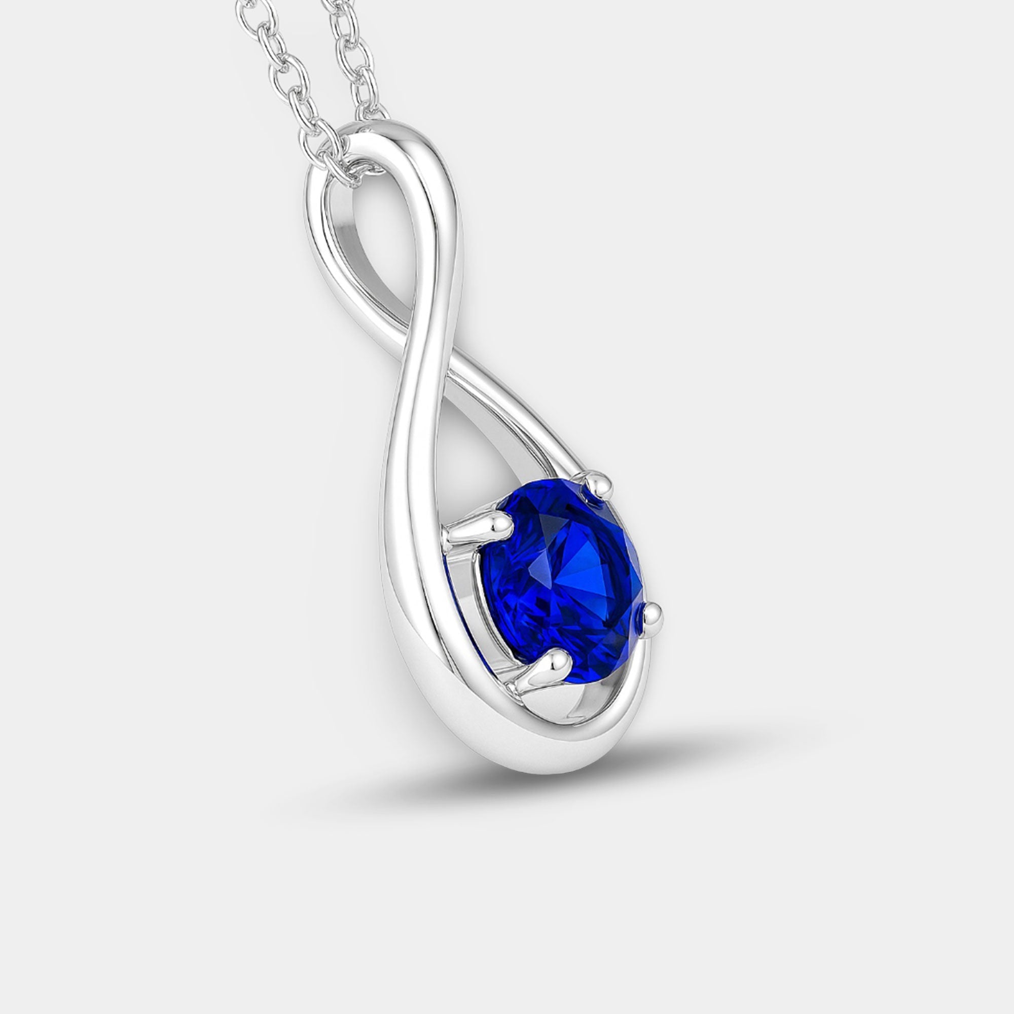 Infinity blue sapphire pendant shown at an angle on a sterling silver chain.