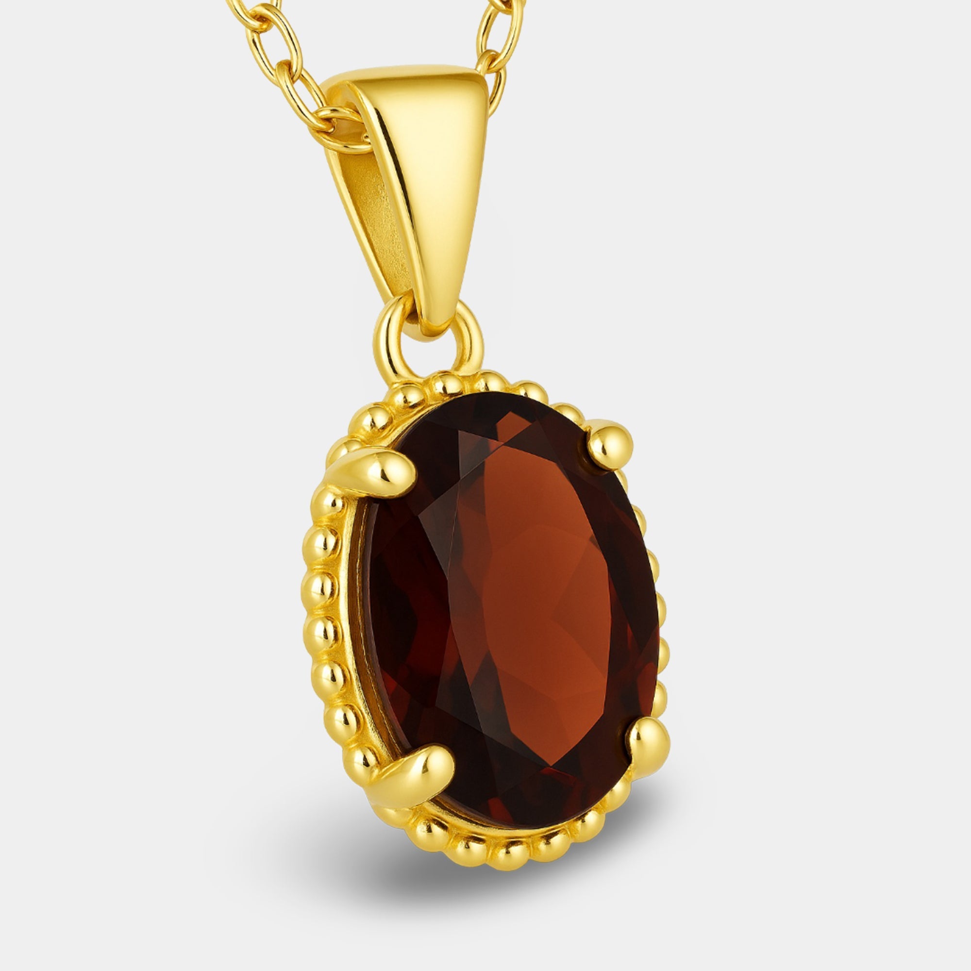 Red garnet oval pendant necklace in gold-plated silver, angled view