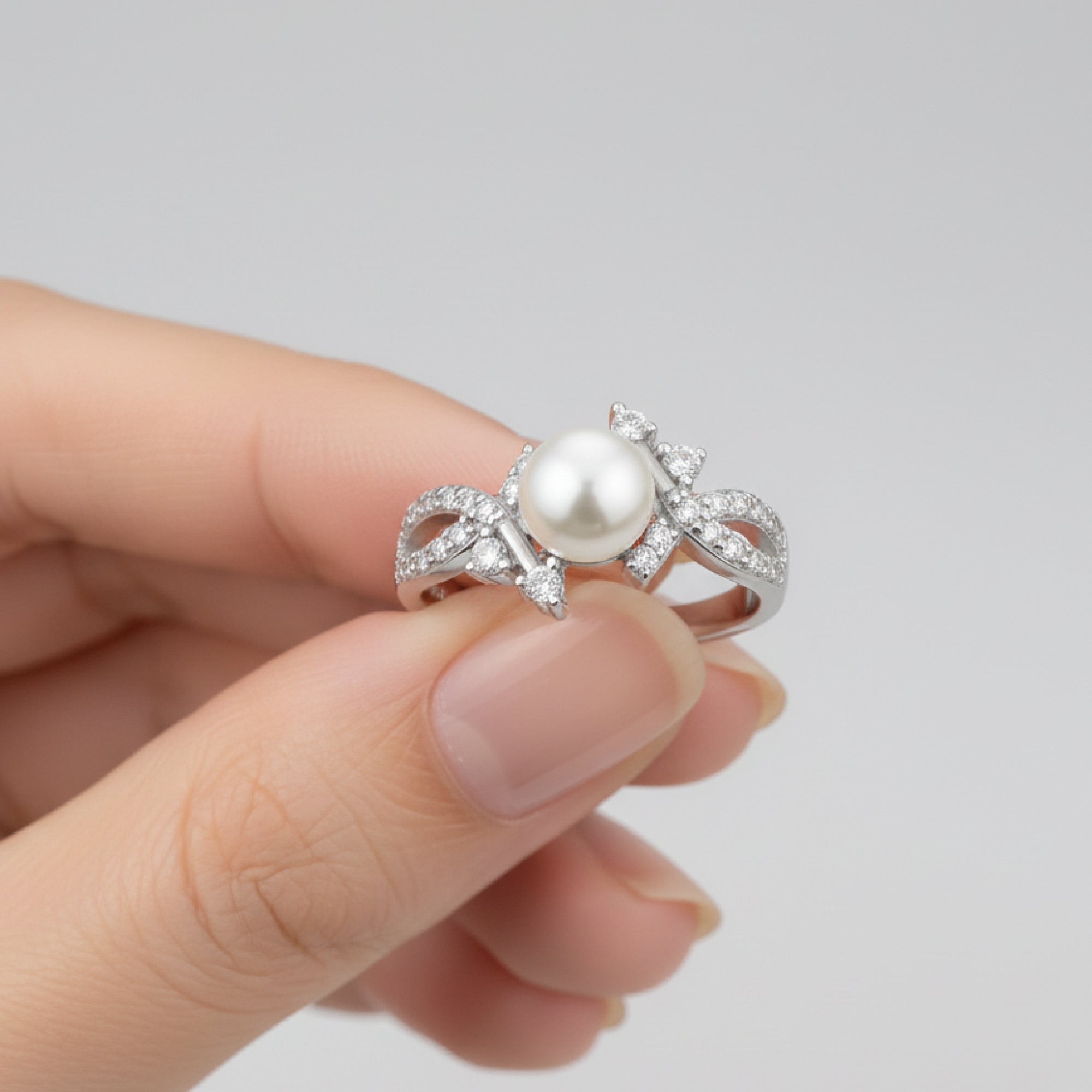 Close-up detail of a 7mm genuine freshwater pearl set in a sterling silver prong setting surrounded by brilliant cubic zirconia stones