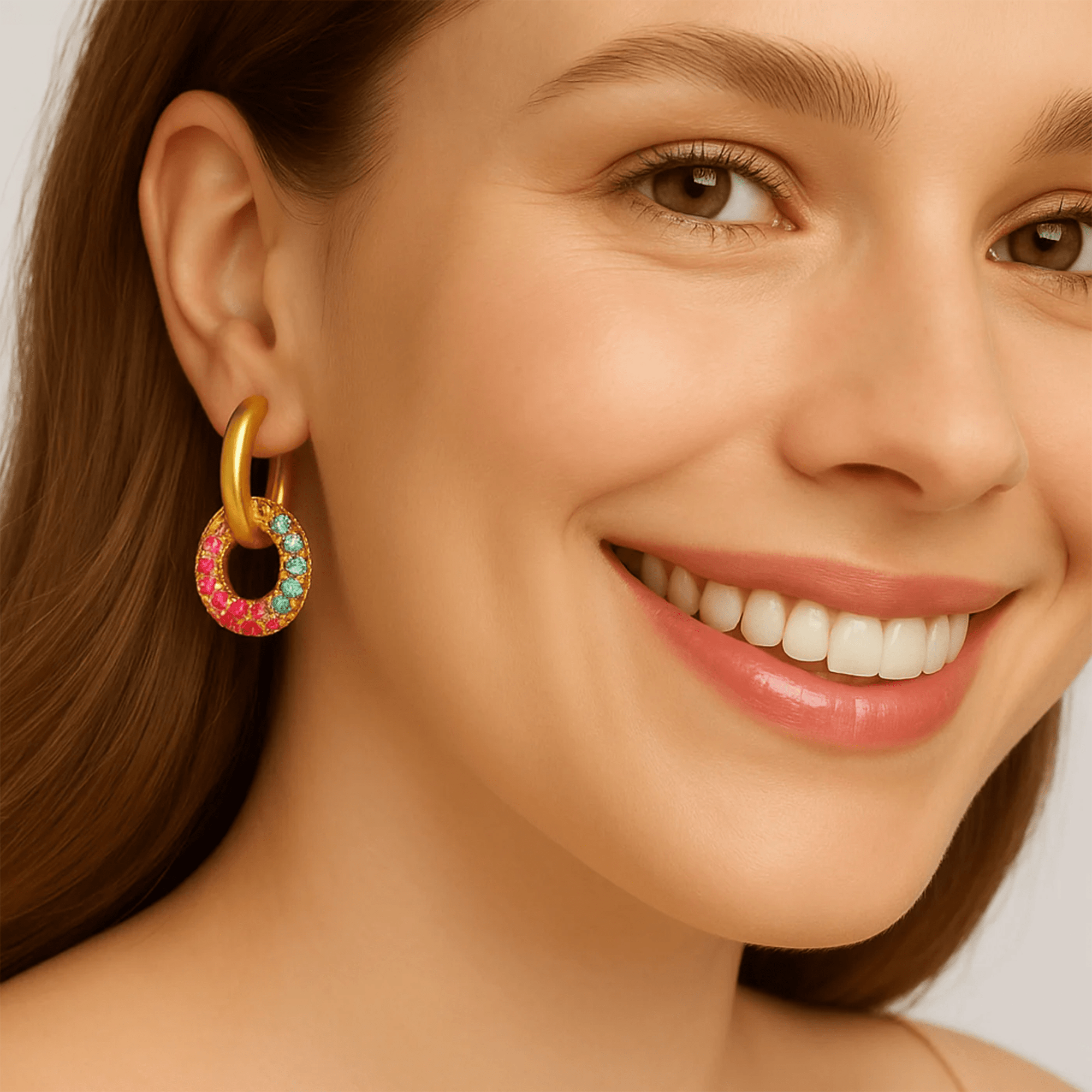 Woman wearing rainbow pavé zircon gold hoop earrings, close-up lifestyle photo on the ear
