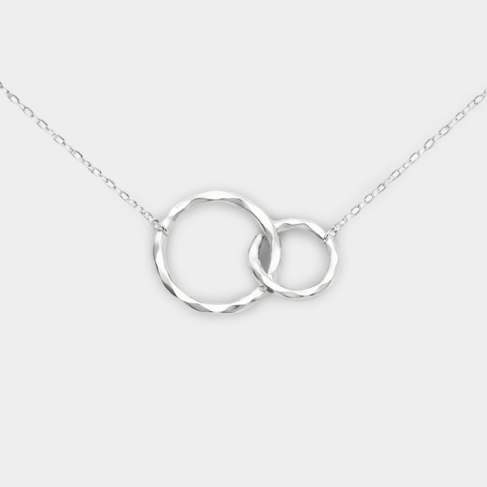 Maid of honor necklace in sterling silver with interlocking circles pendant on a cable chain, flat lay on white background