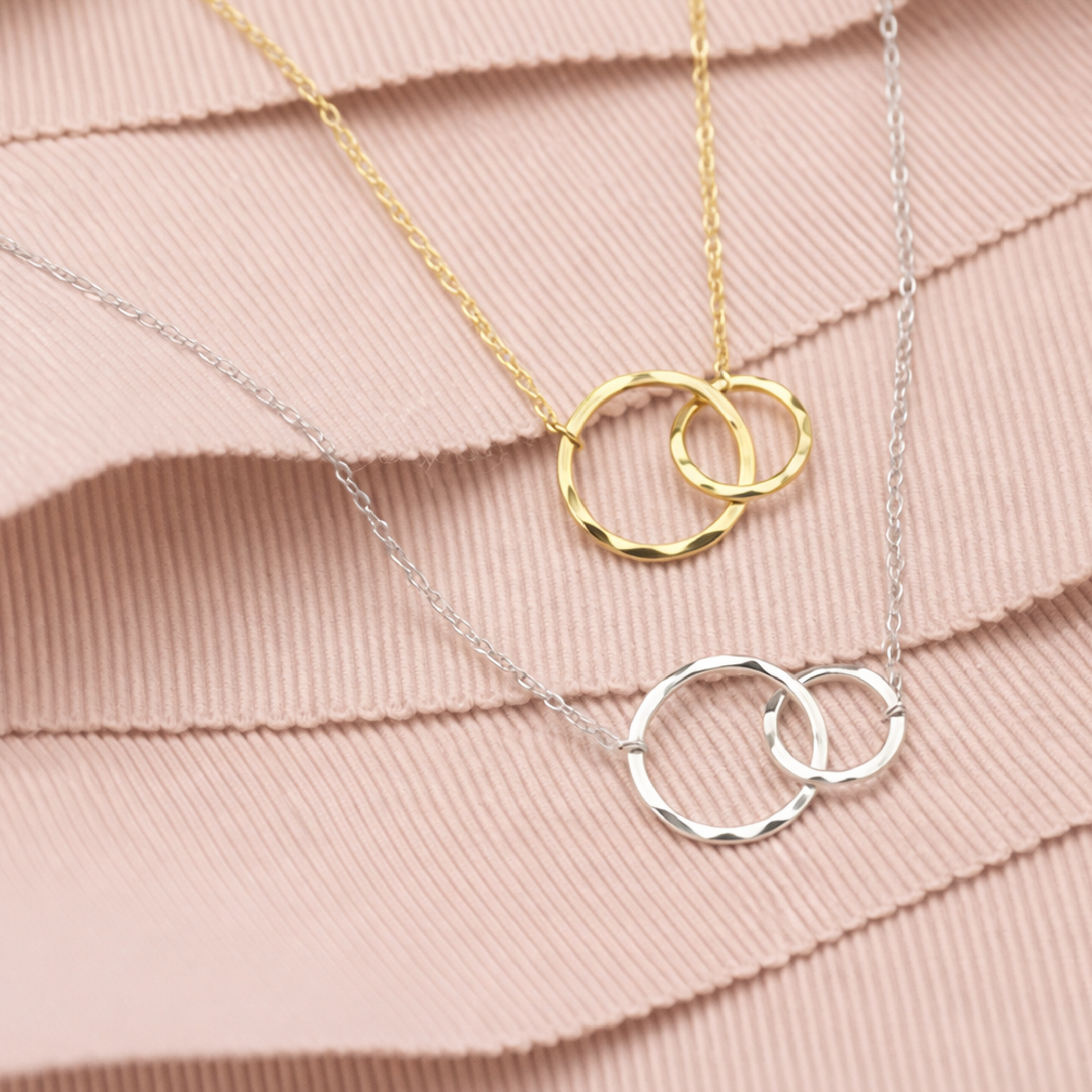 Sterling silver and gold interlocking circle maid of honor necklaces on a blush pink ribbon, gift-ready presentation