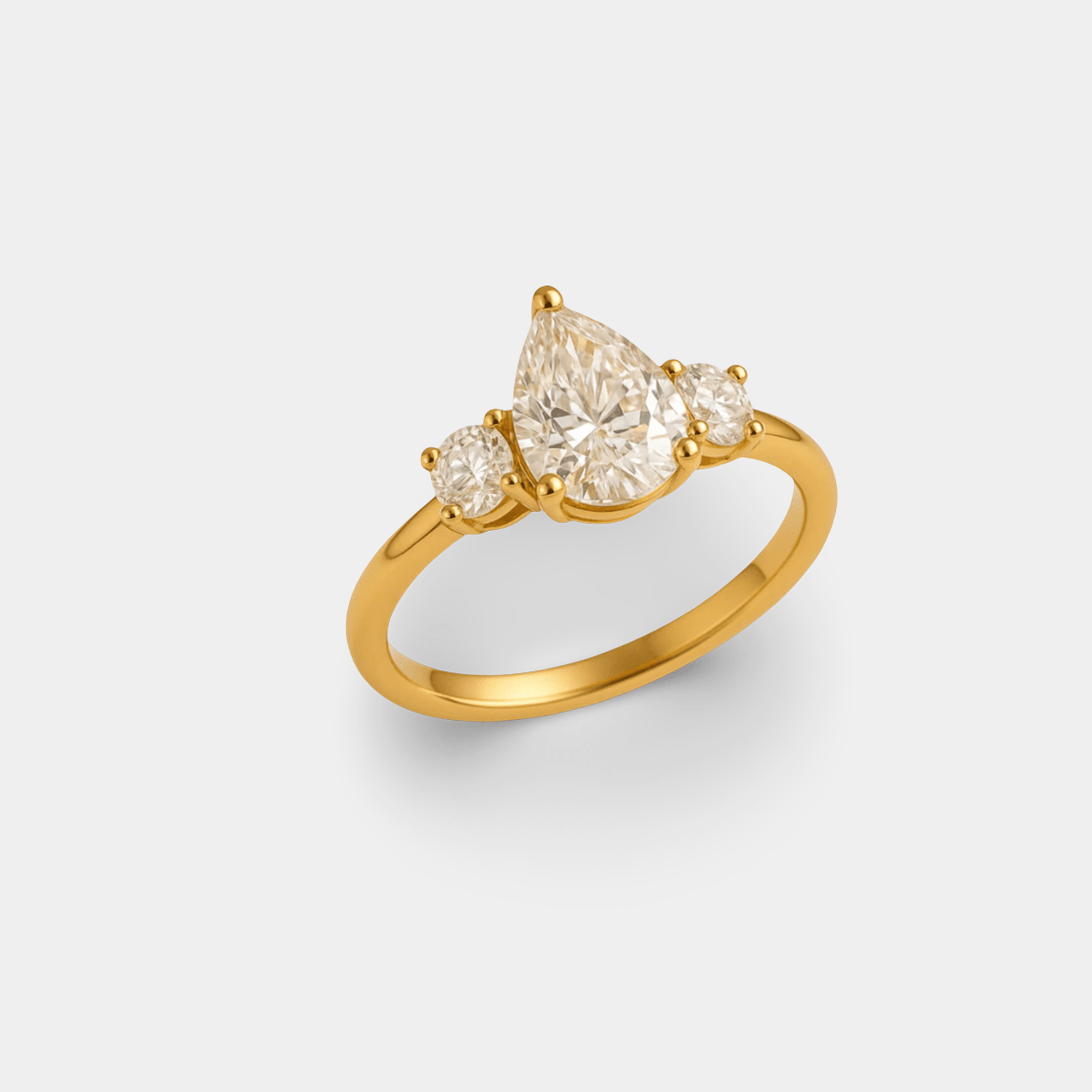 Three-quarter angled view of the pear-shaped CZ center stone and polished gold band on the majestic ring