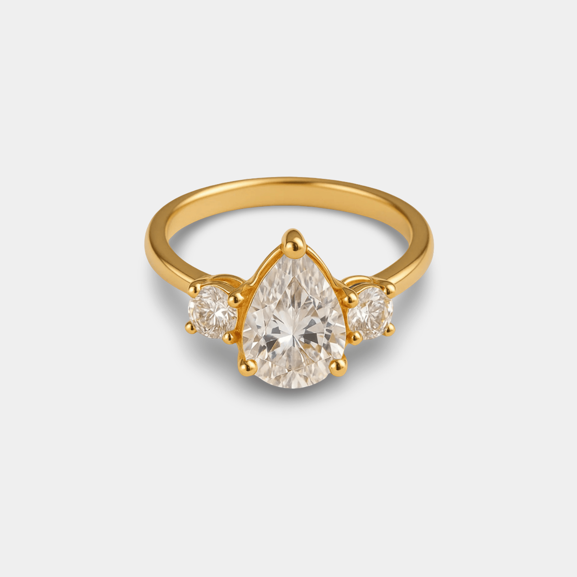 Majestic pear zircon ring with a pear-cut CZ center and two round accents in a 14K gold three-stone setting, front view