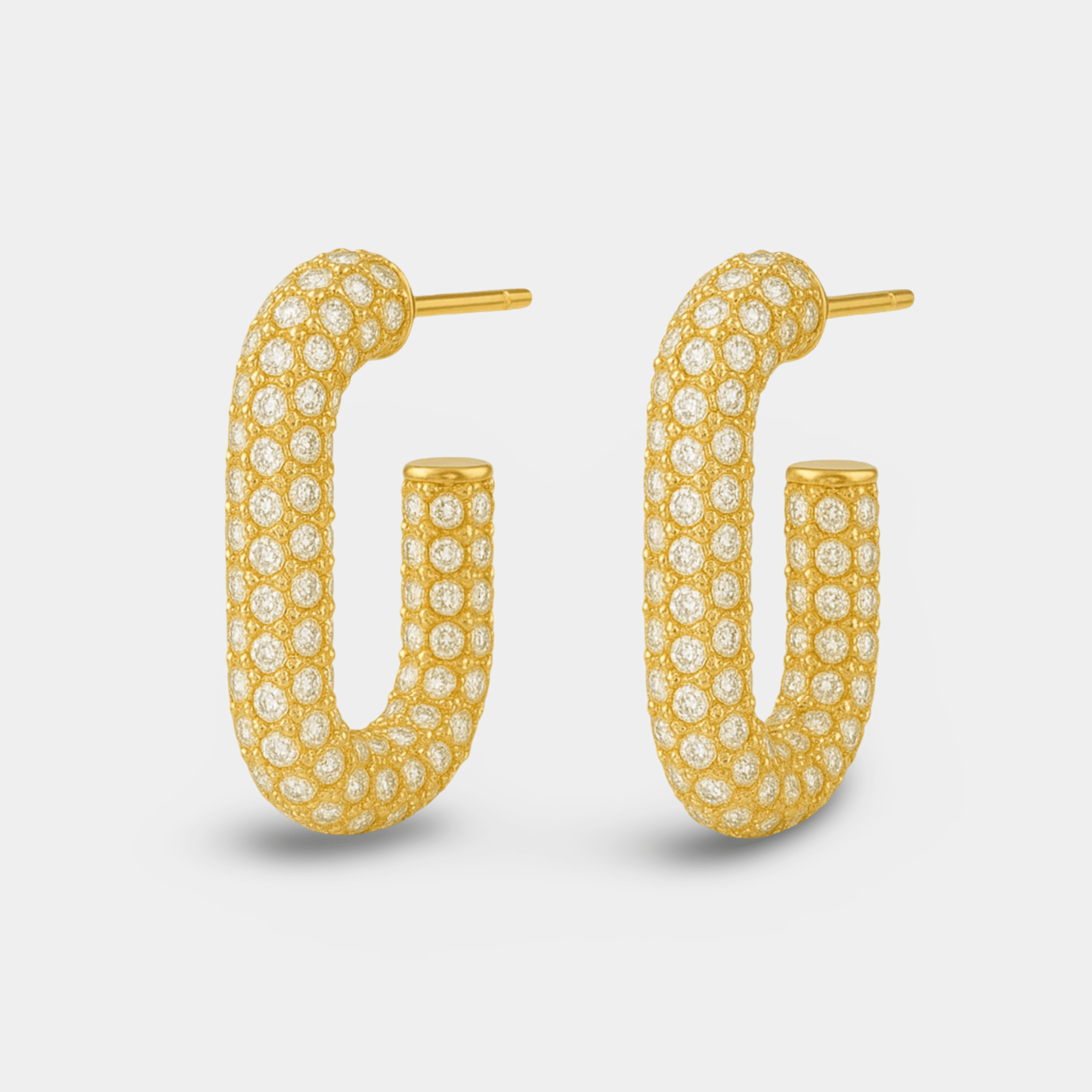 Gold pavé hoop earrings shown on an ear
