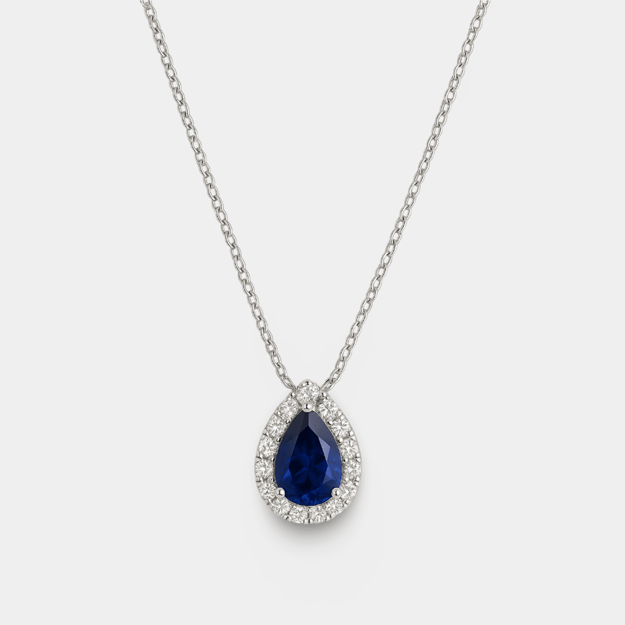 Close-up of the pear-shaped blue sapphire framed by a diamond halo