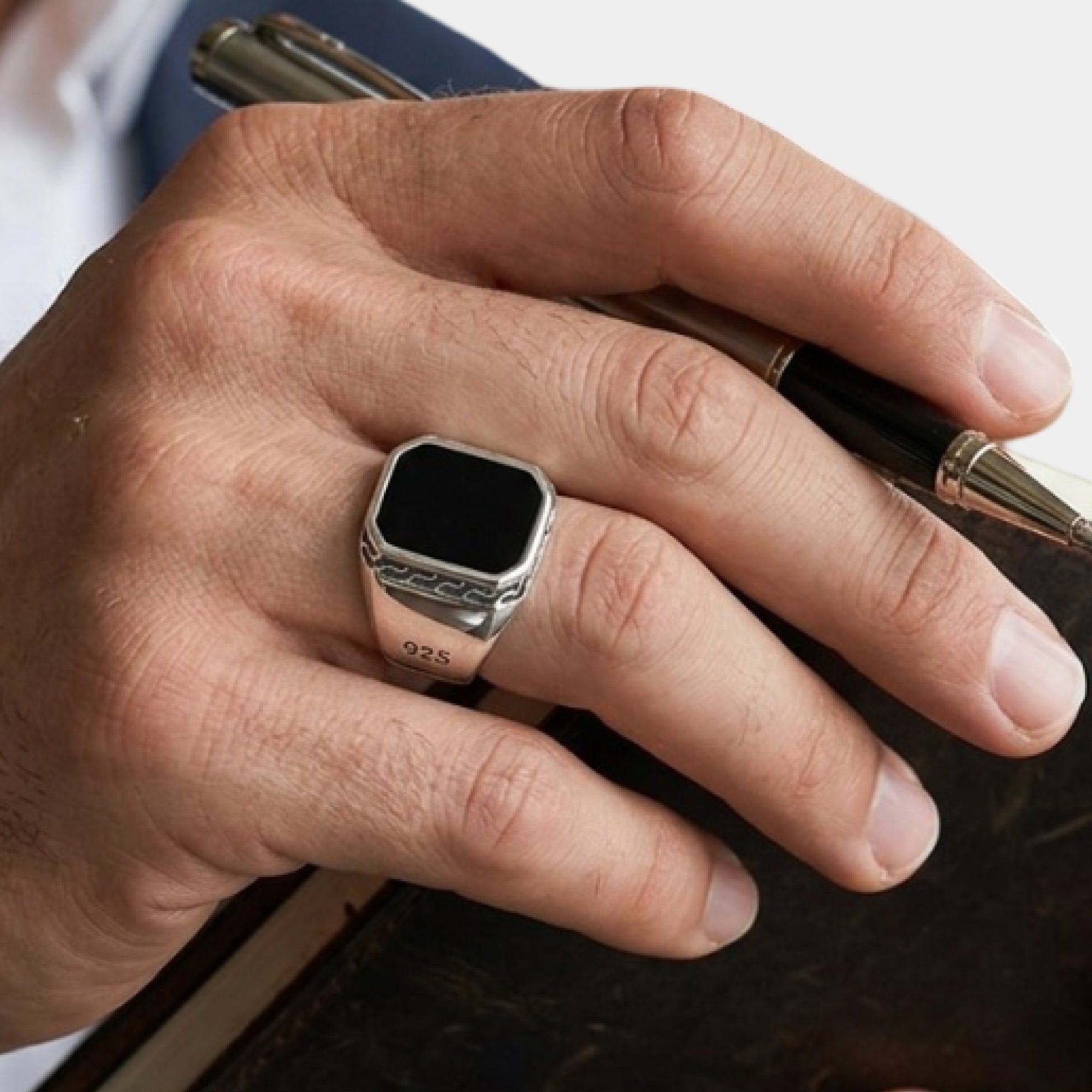Close-up of the square black onyx stone on a men's silver signet ring
