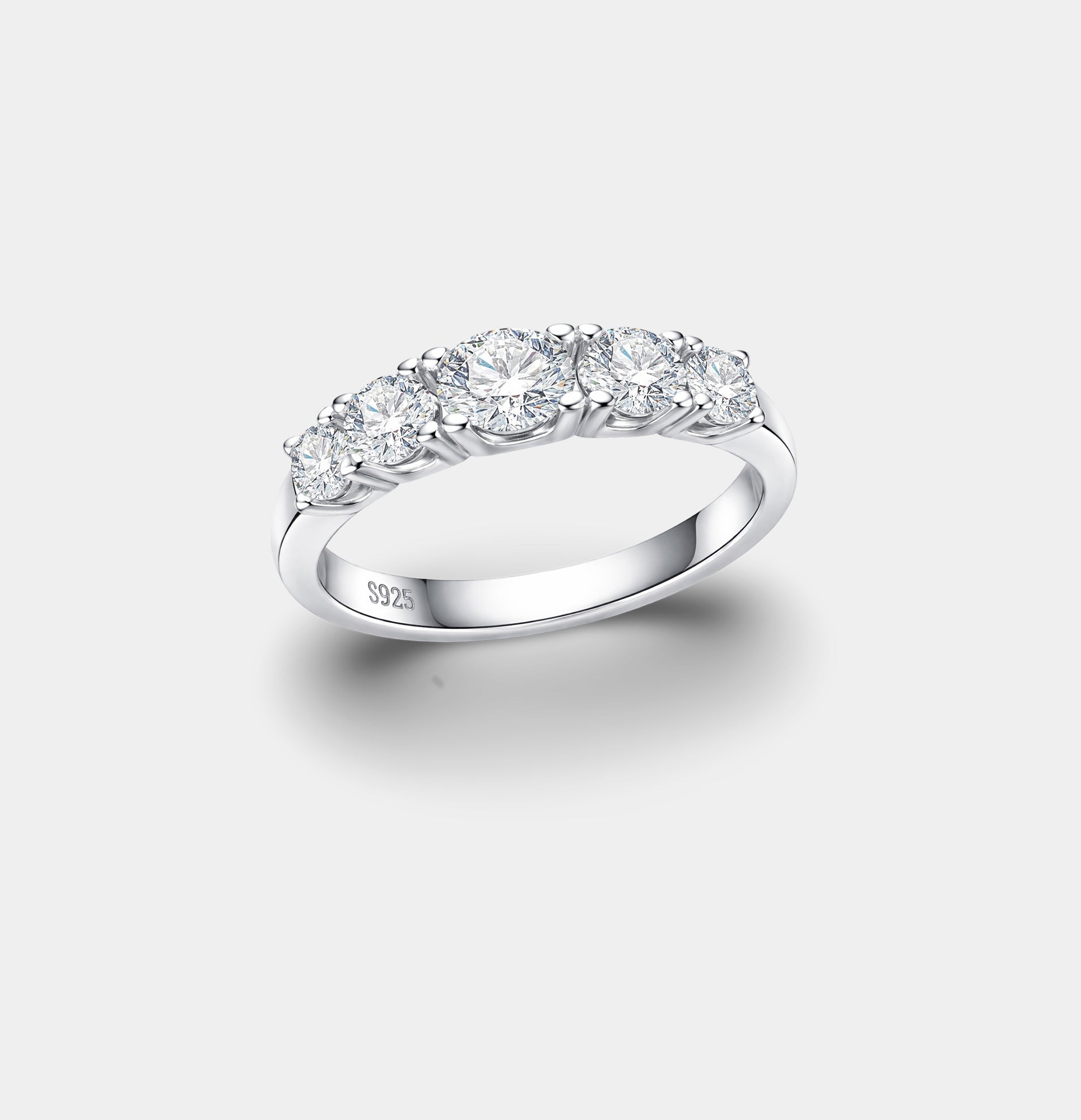 Close-up of five round brilliant moissanite stones in a silver prong setting