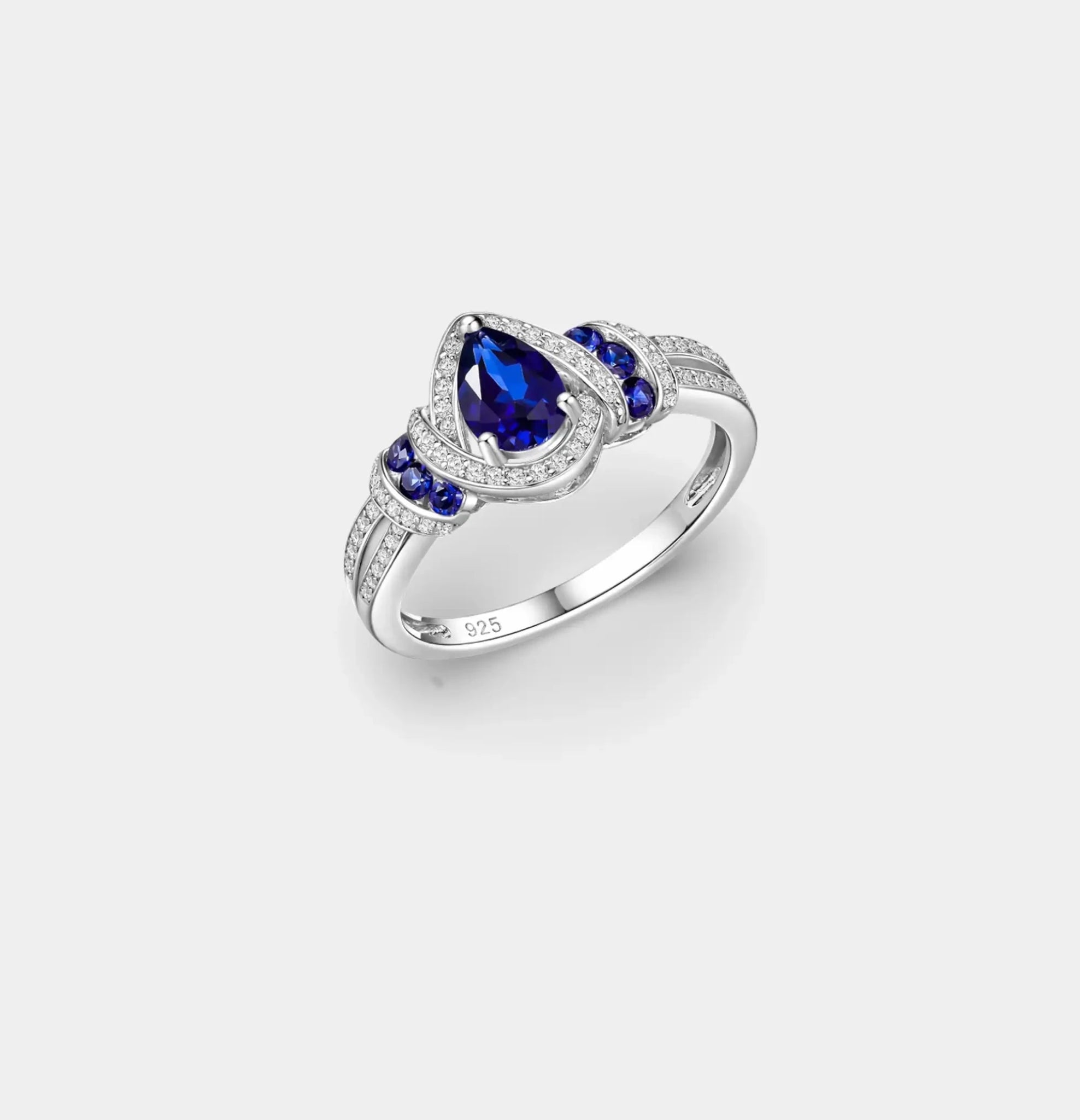 Pear-cut blue sapphire engagement ring in sterling silver with a cubic zirconia halo, front view