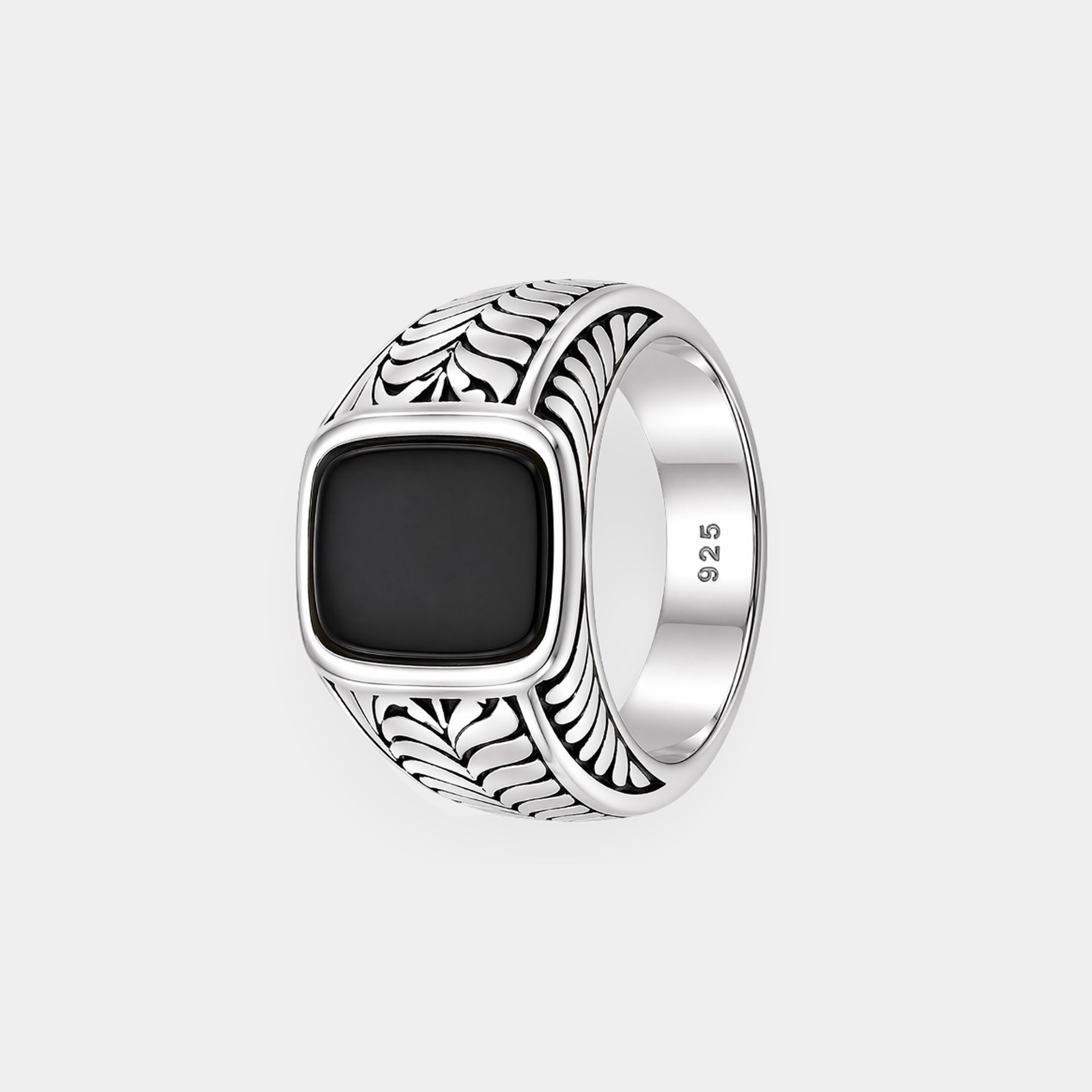 Bezel-set black onyx men's ring on a flat surface