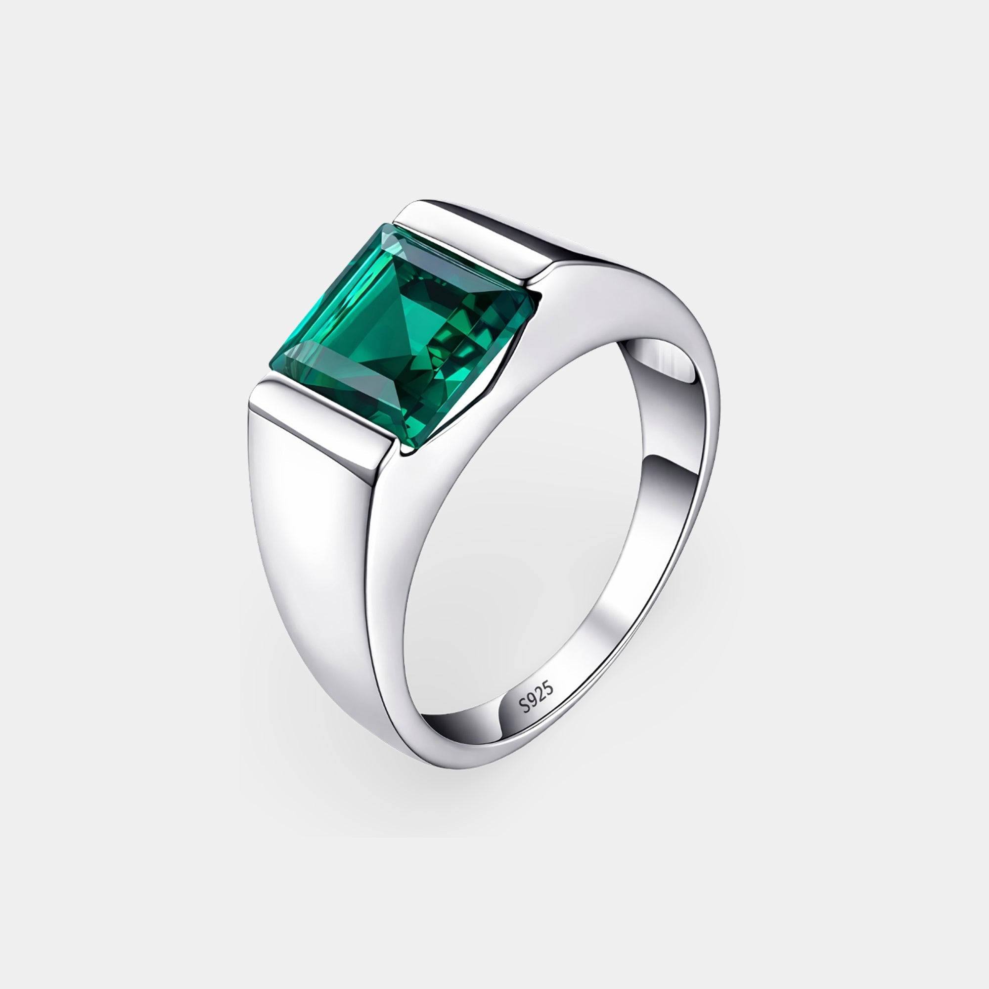 Sterling silver square emerald men's ring on a flat surface