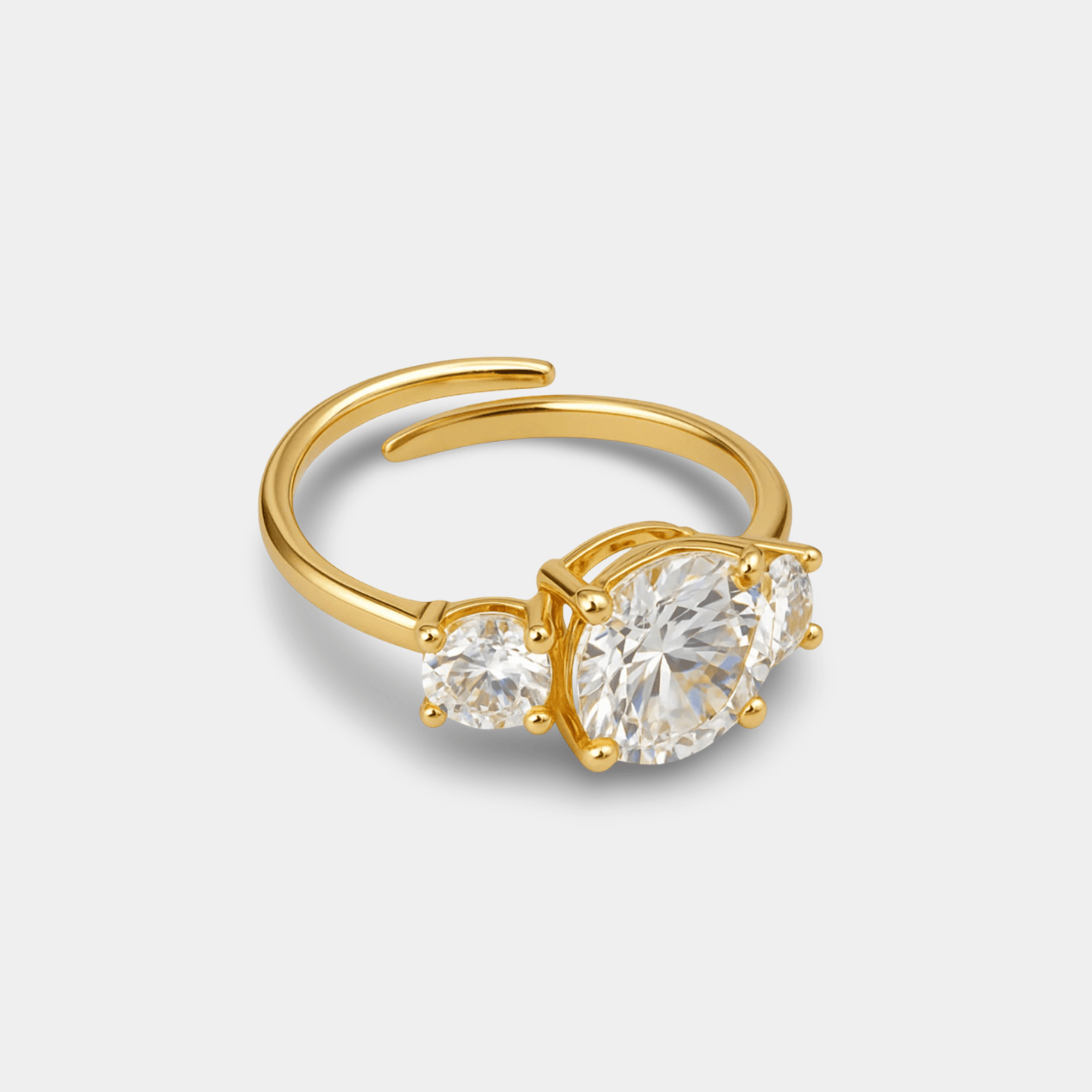Triple stone zircon ring in 14K gold plated stainless steel with three round cubic zirconia stones on an adjustable open band, angled view