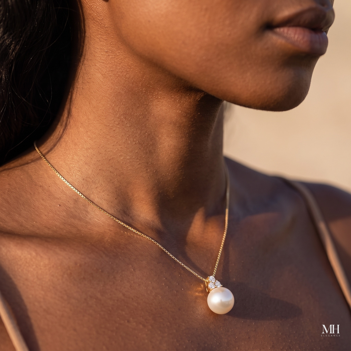 Close-up of freshwater pearl pendant necklace worn at the collarbone, 14K yellow gold chain