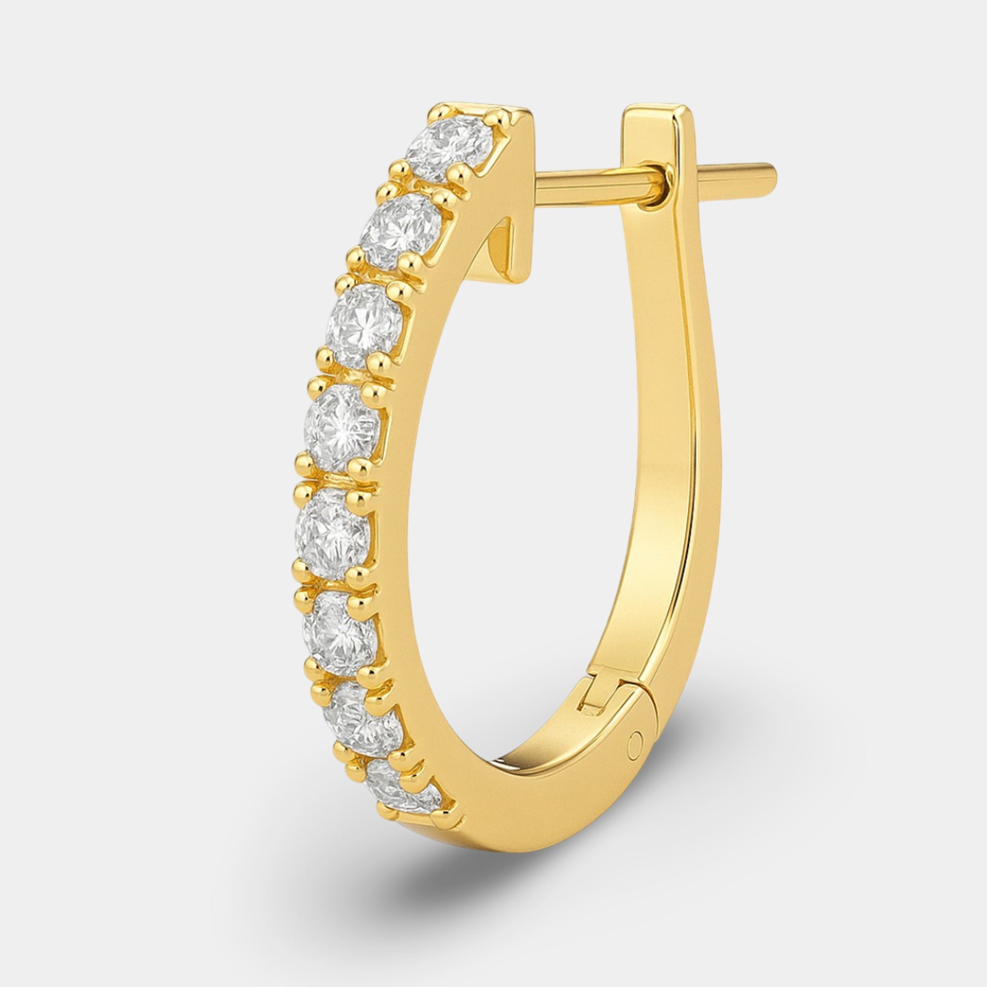 Close-up of a single cubic zirconia huggie hoop earring showing the sparkling stones