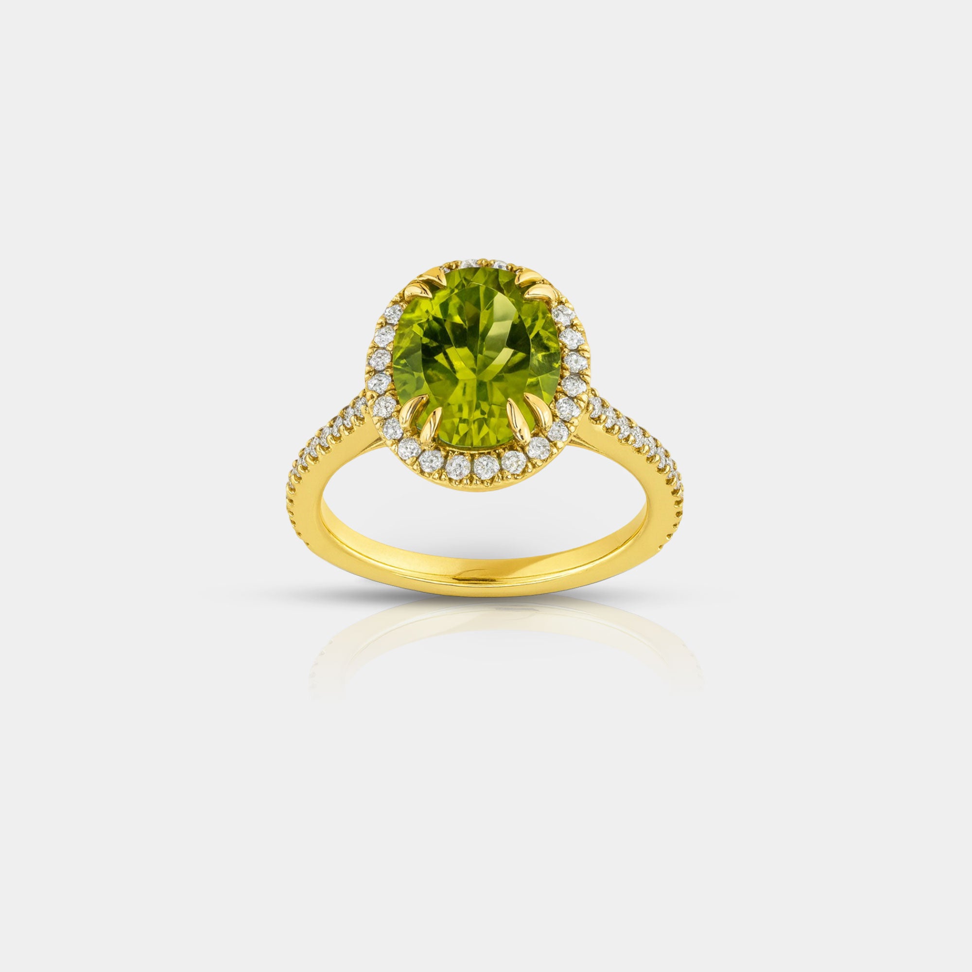 Anillo de peridoto verde de talla ovalada y halo de diamantes