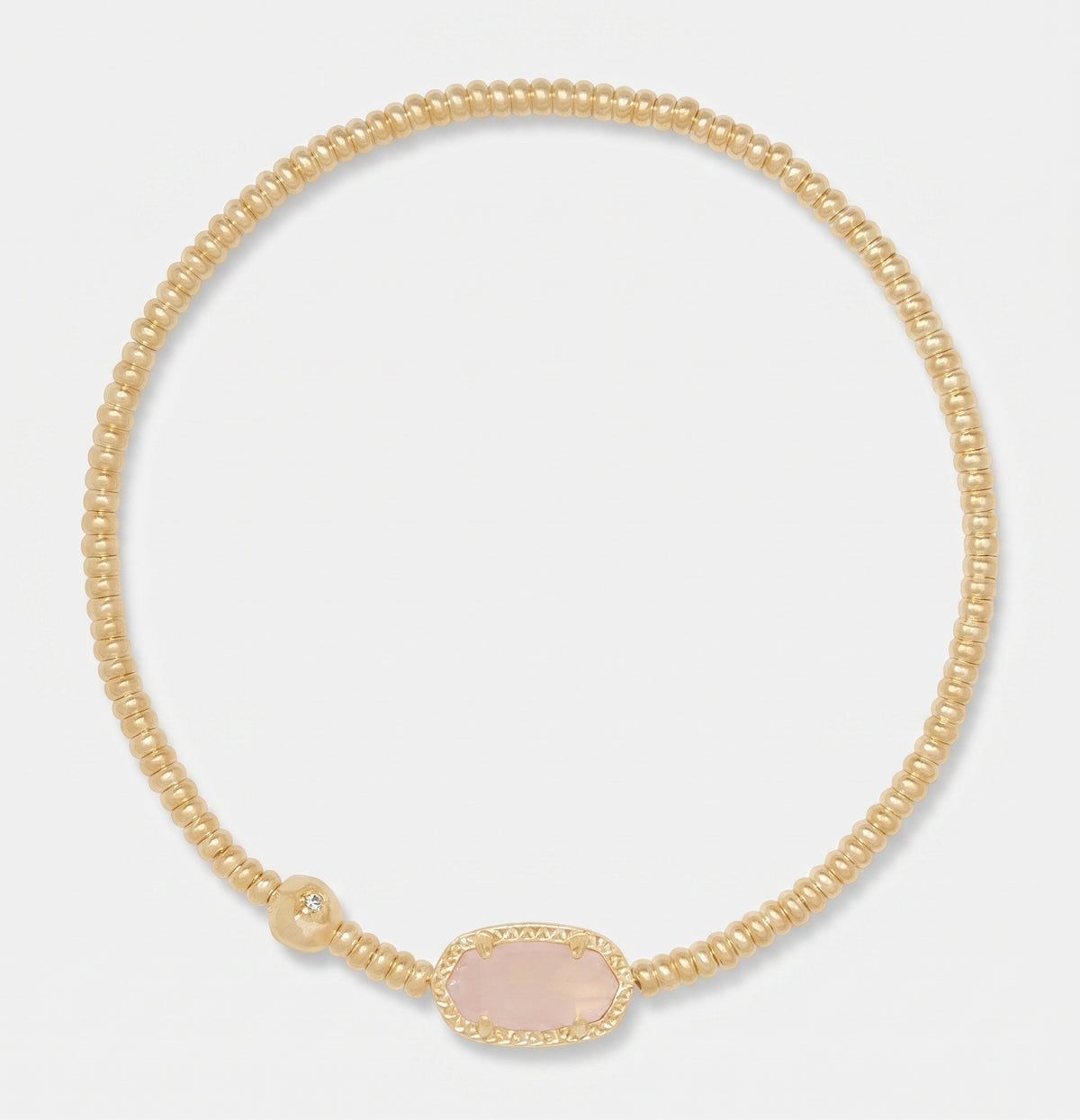 A delicate gold beaded necklace with a central oval pale pink stone, displayed on a clean light gray background.