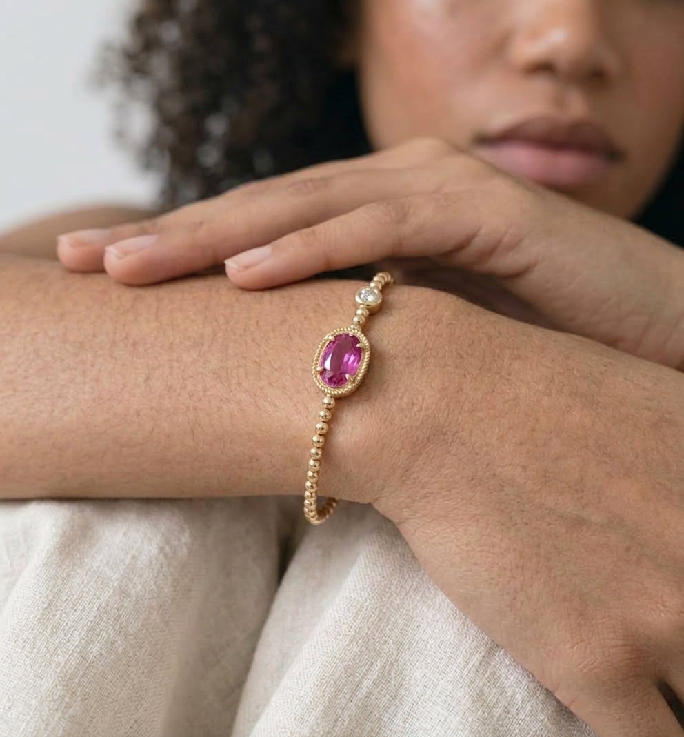 Woman wearing a pink crystal gold beaded stretch bracelet on her wrist