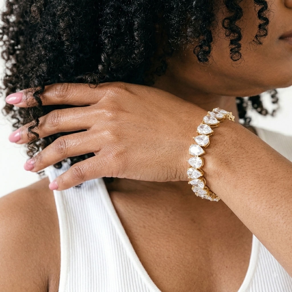 Gold plated tennis bracelet with pear cubic zirconia stones worn on wrist
