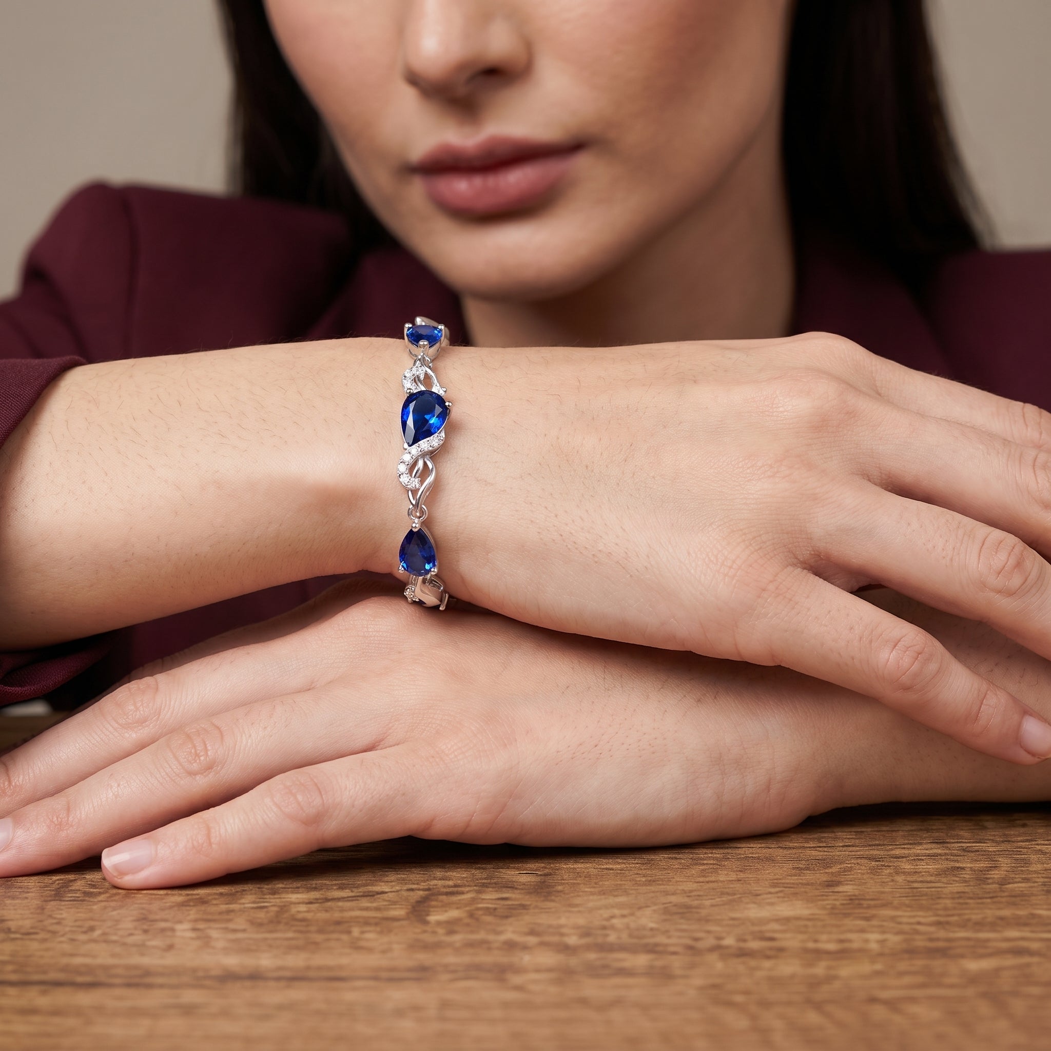 Woman wearing sterling silver sapphire teardrop bracelet on her wrist