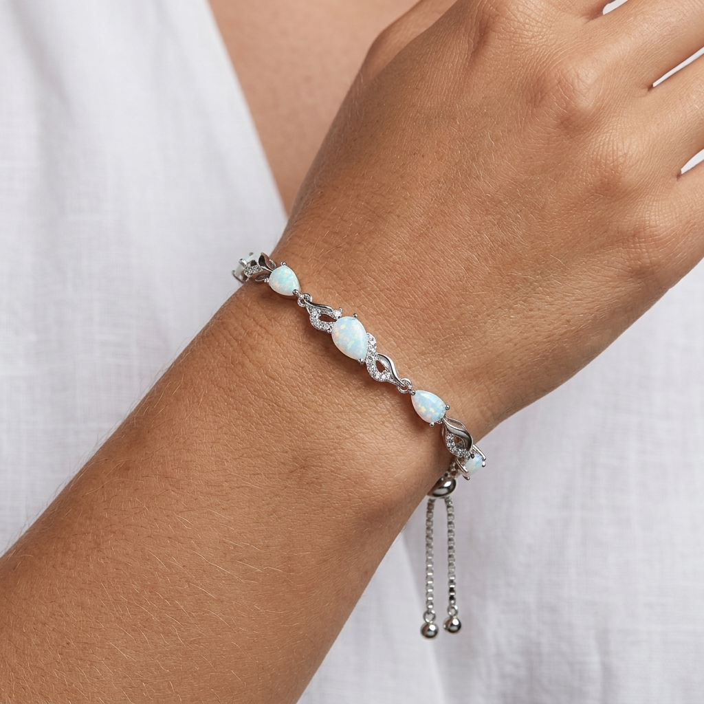 Close-up of the opal teardrop bracelet worn on a woman's wrist, showing the sparkle of the CZ accents.